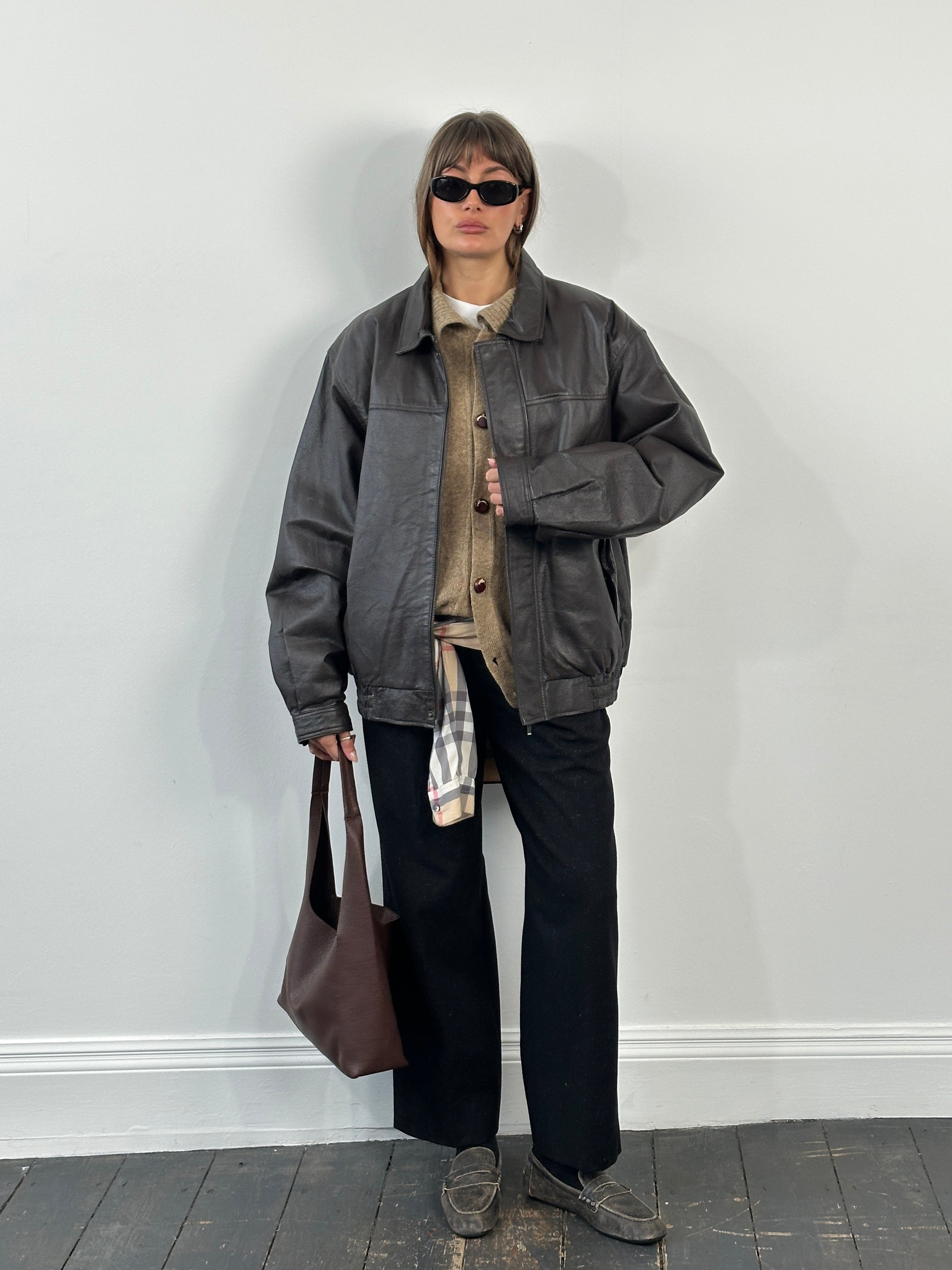 Vintage 1990s leather bomber jacket with concealed placket in XL/XXL size, featuring classic design and aged leather finish.