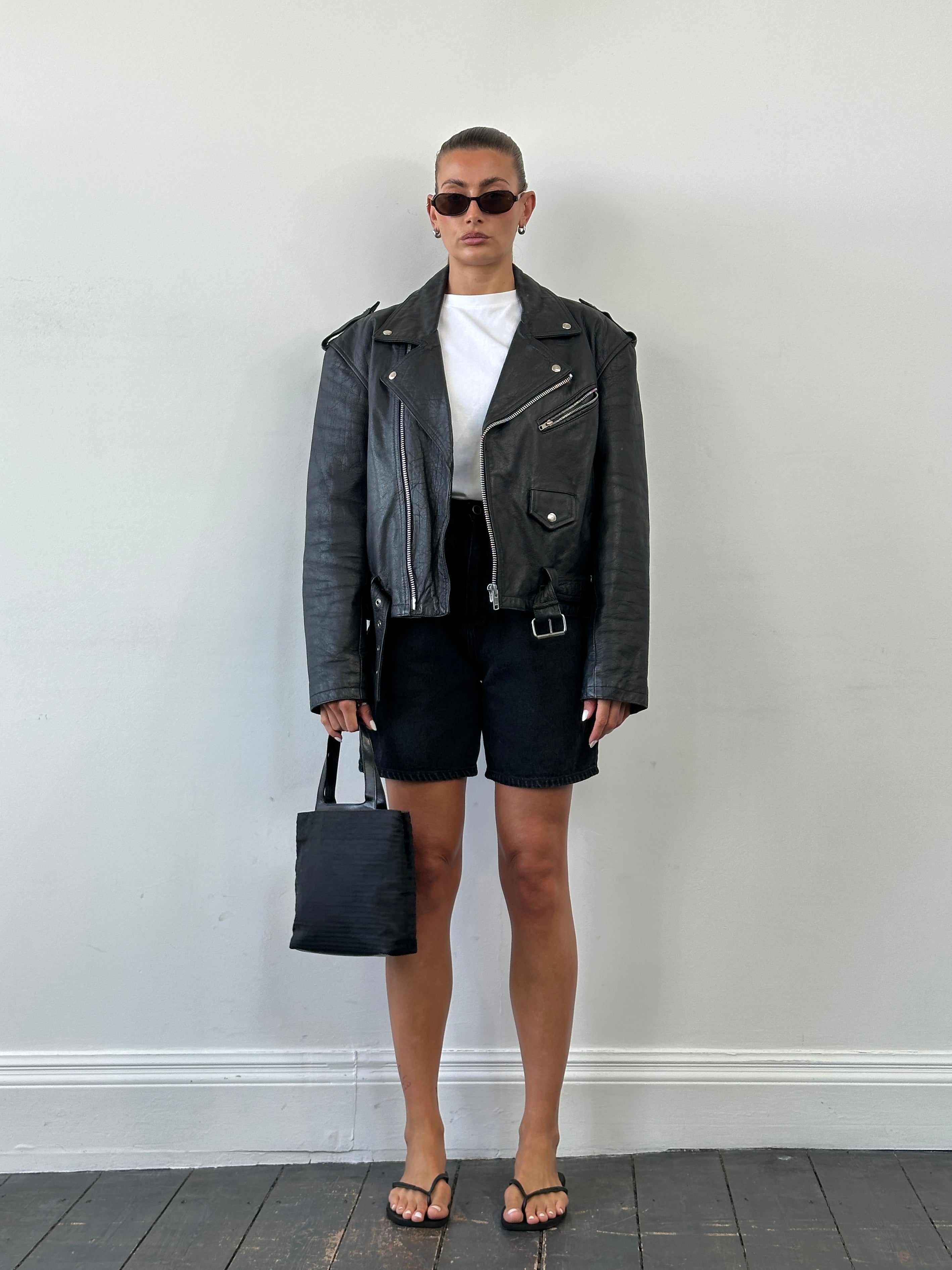 Vintage leather biker jacket from the 1990s, size large, with classic distressed leather and zippered front details.