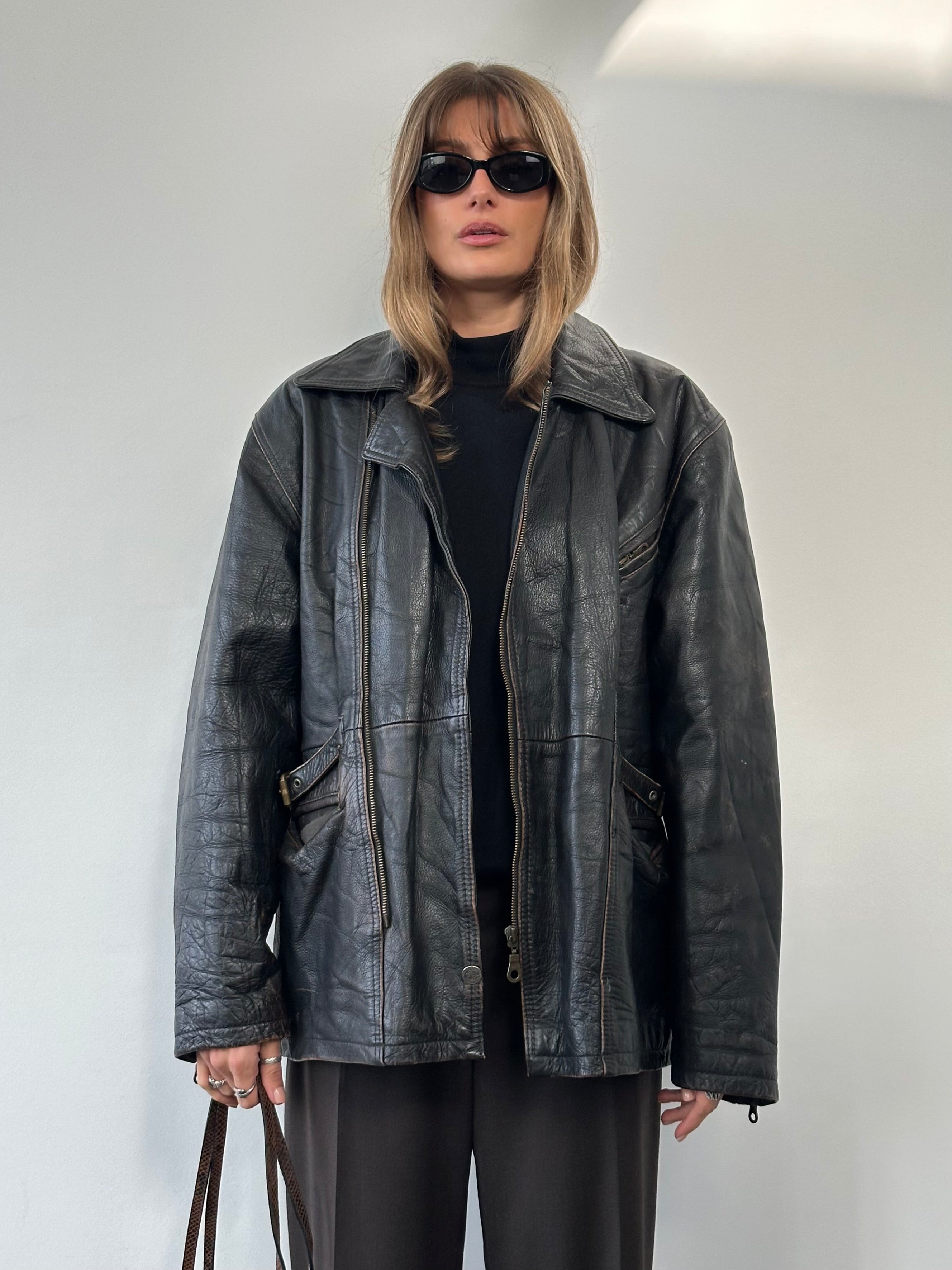 Vintage distressed leather jacket in XL size, featuring rugged texture and classic style, shown on a hanger.