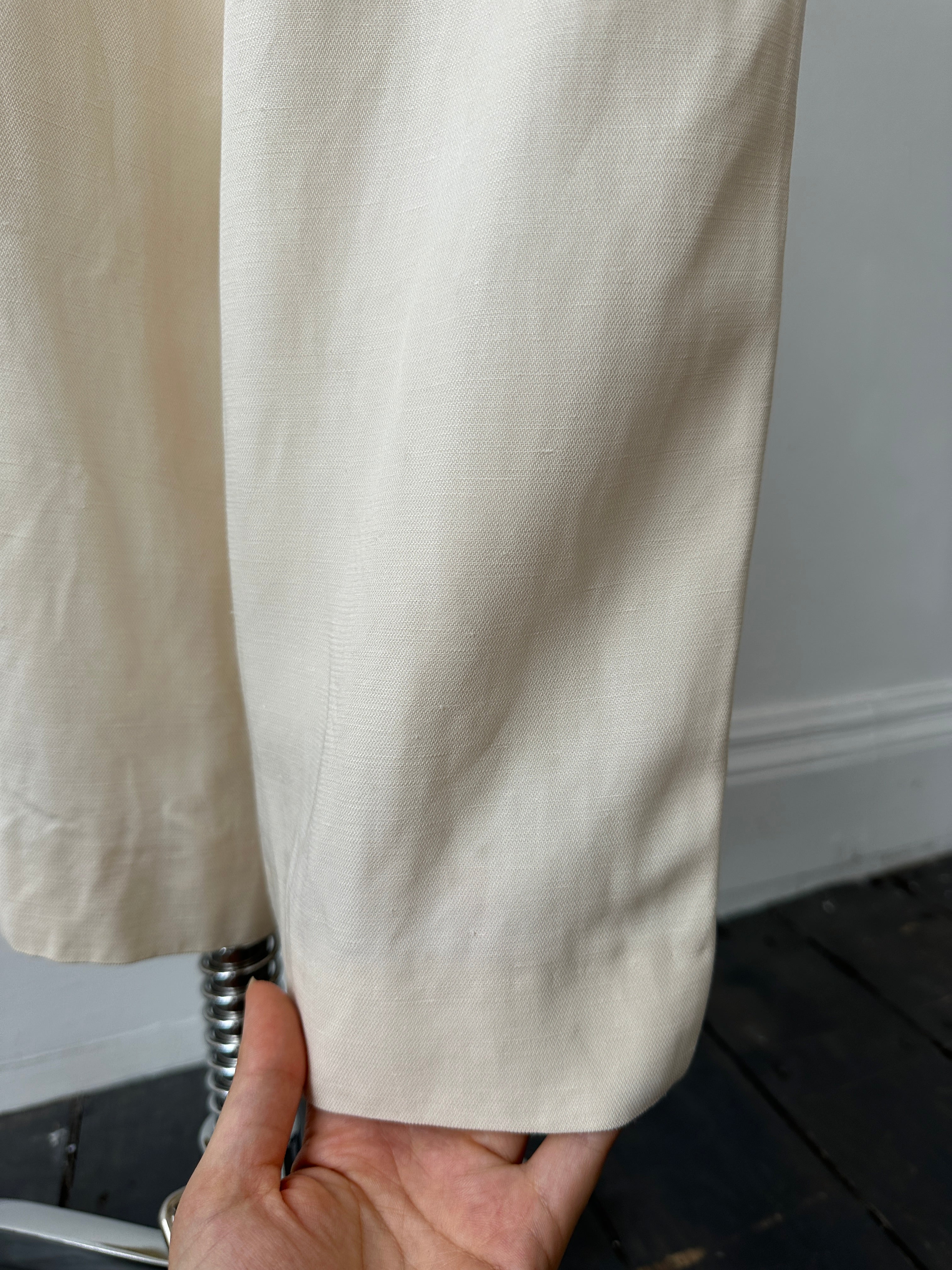 Giorgio Armani 1990s wide leg tailored trousers in beige, high-waisted with crisp pleats, W28 size, displayed on a hanger.