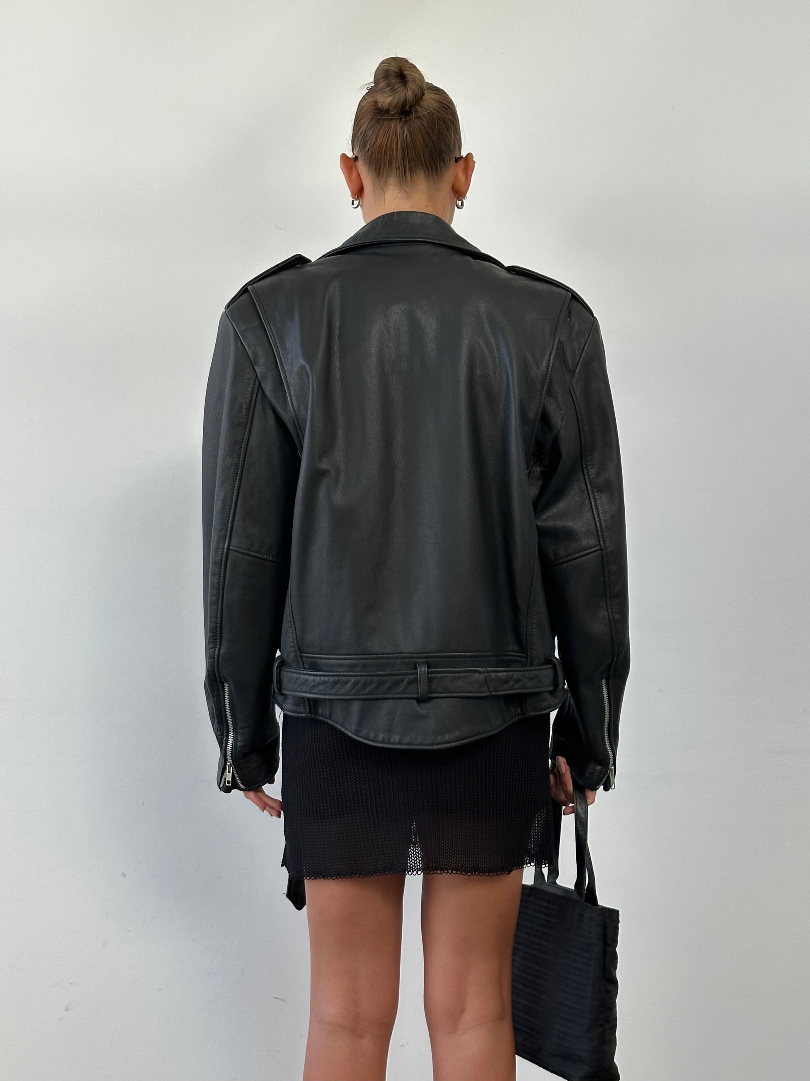 Vintage leather biker jacket in size M/L with classic design, featuring rugged leather and detailed stitching.