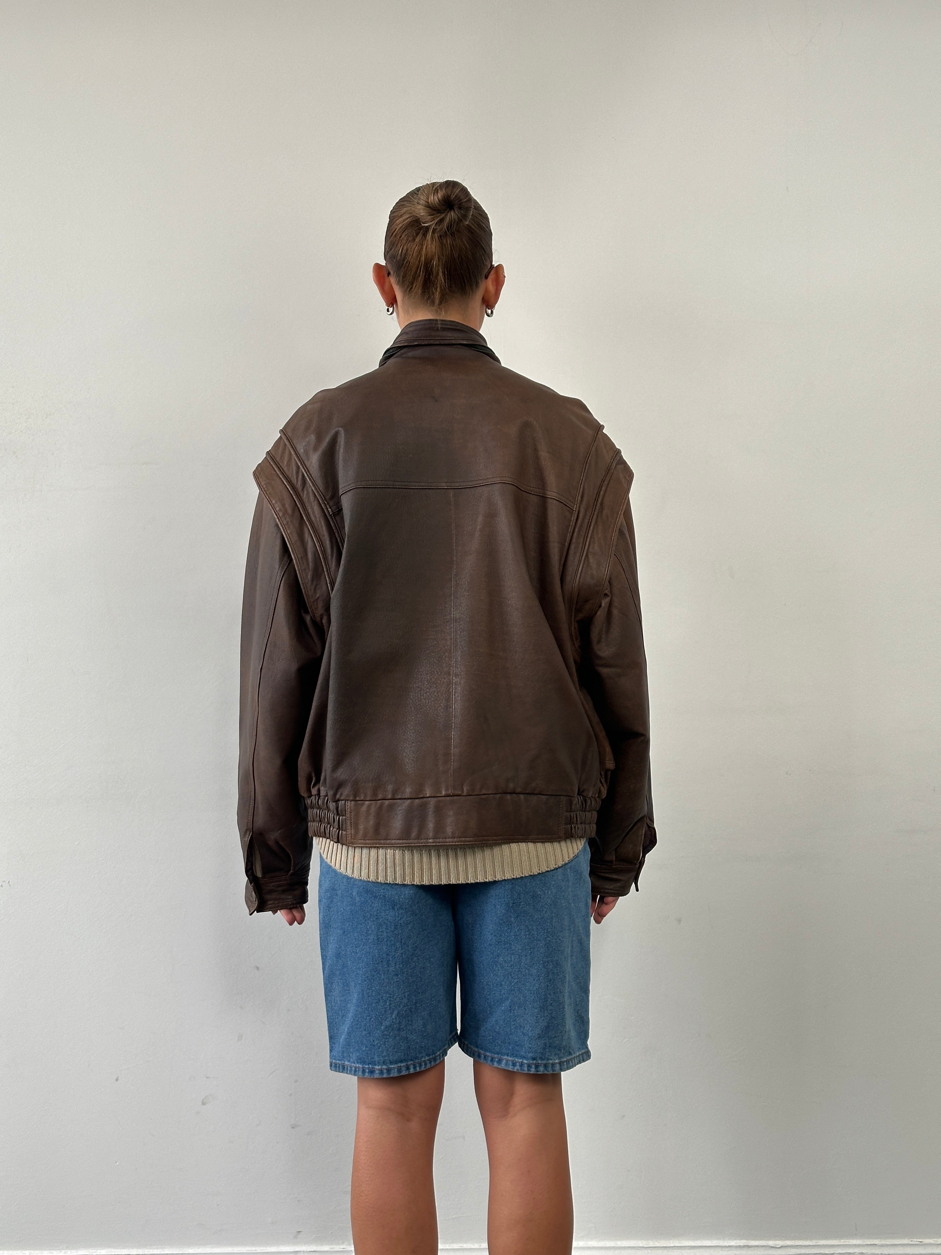 Vintage high neck aged leather bomber jacket in size L/XL, featuring a classic design and distressed leather finish.