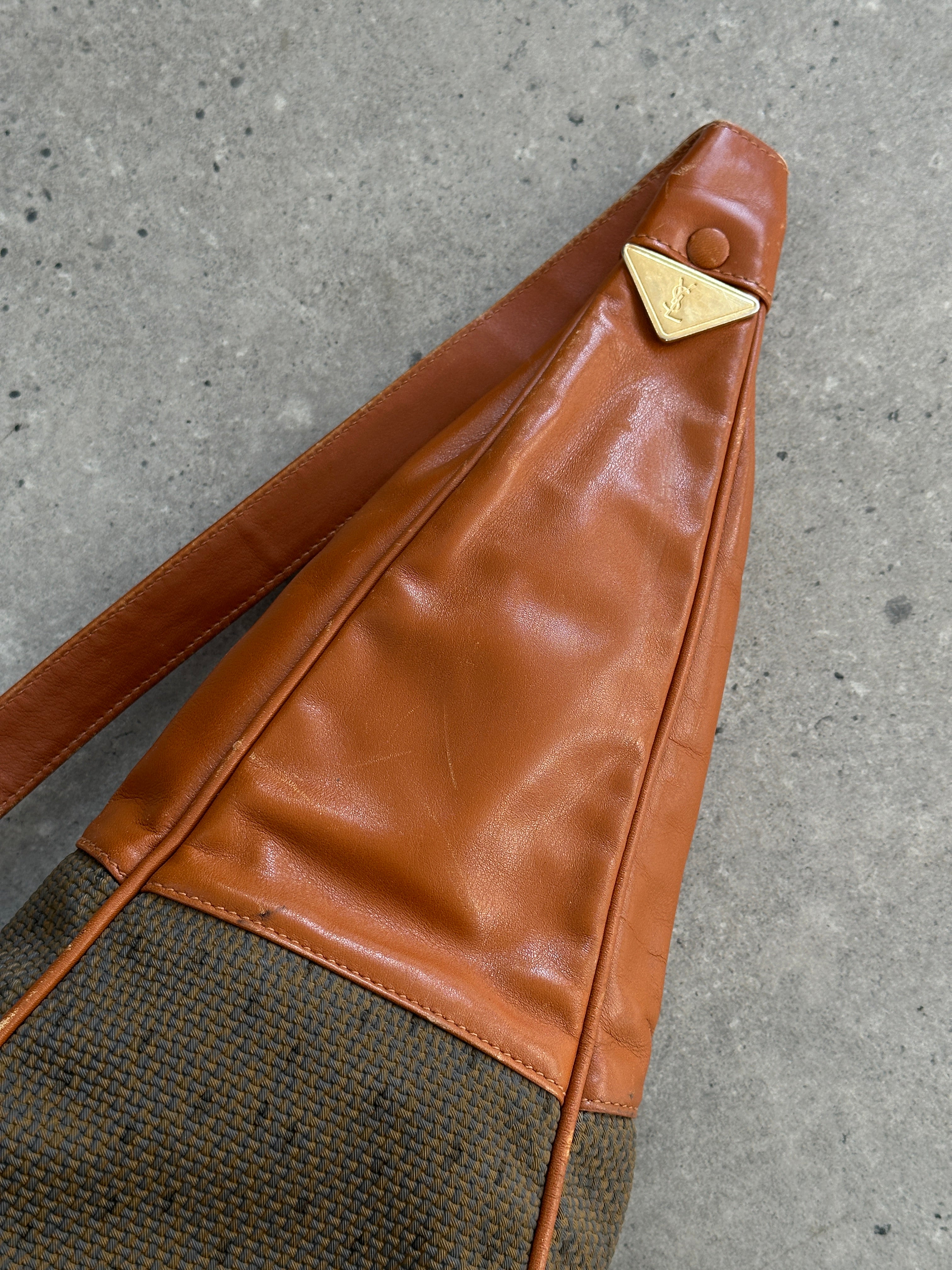 Yves Saint Laurent Paris 80s leather sling bag featuring a sleek design with adjustable strap and classic black leather finish.