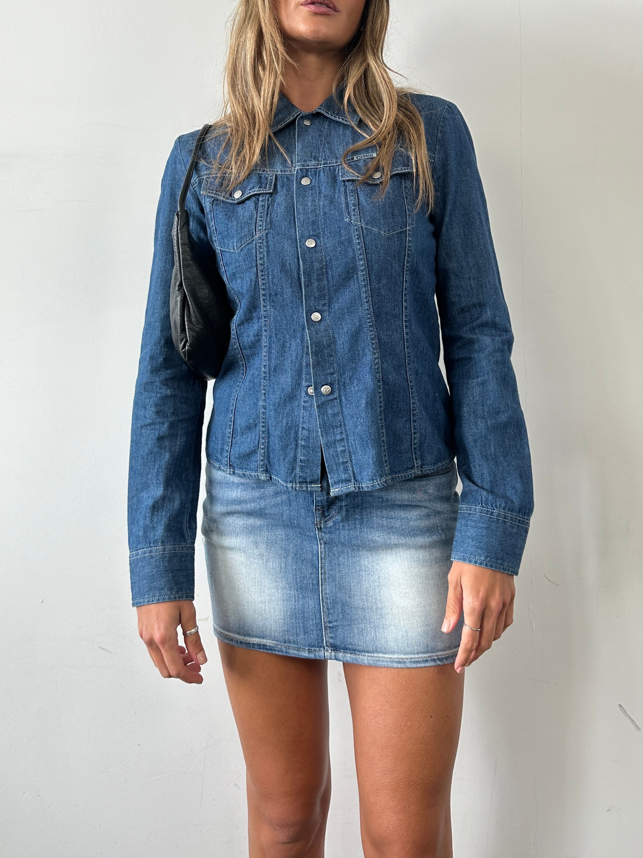Diesel fitted denim shirt in size small, shown on a hanger with visible button details and classic blue denim fabric.