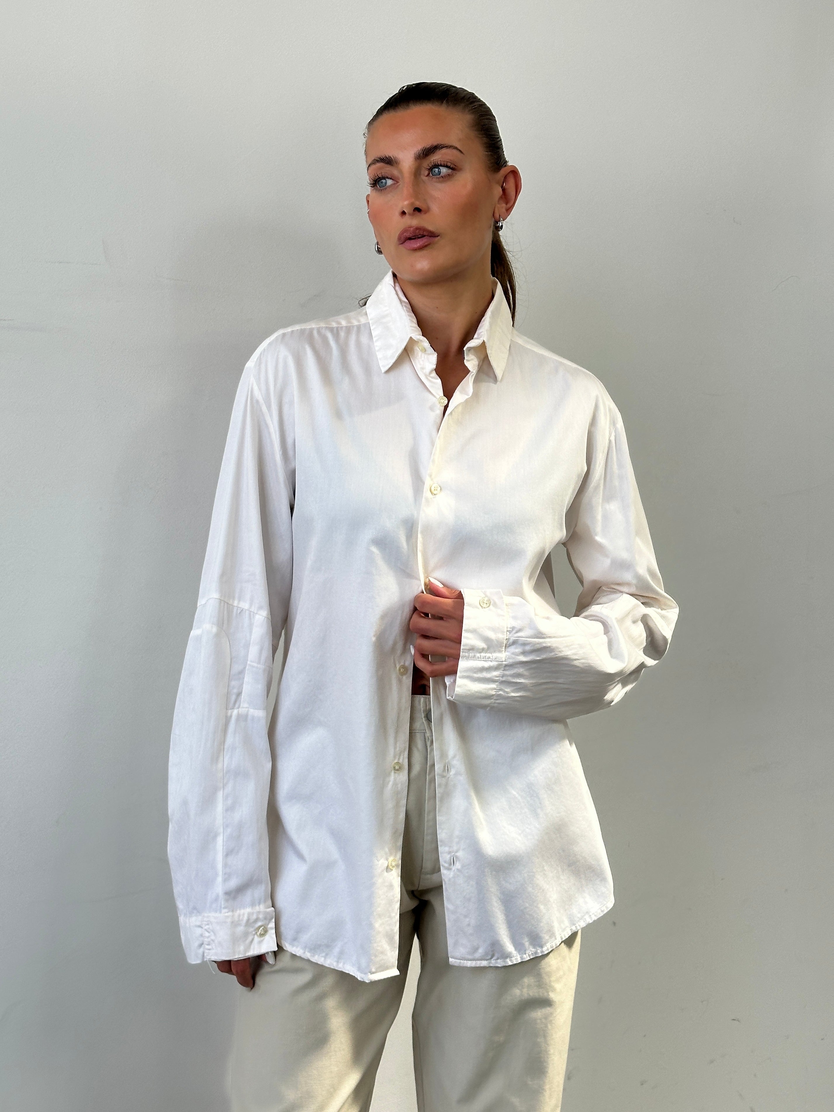 Versace Sport 90s pure cotton shirt in size L, featuring classic design and soft fabric, displayed on a hanger against a neutral background.