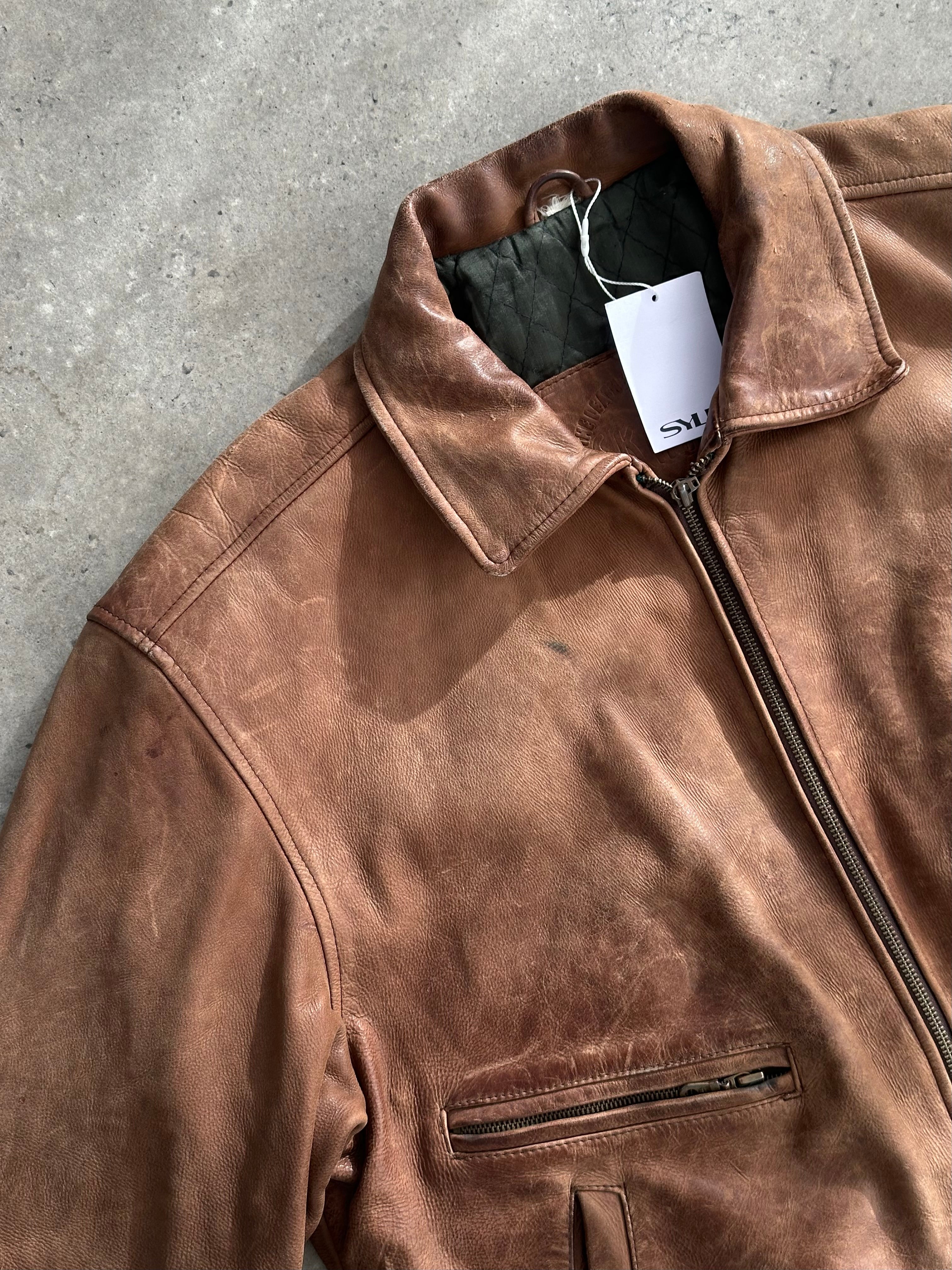 Vintage distressed leather bomber jacket in XL size, featuring rugged texture and classic style, displayed on a hanger.