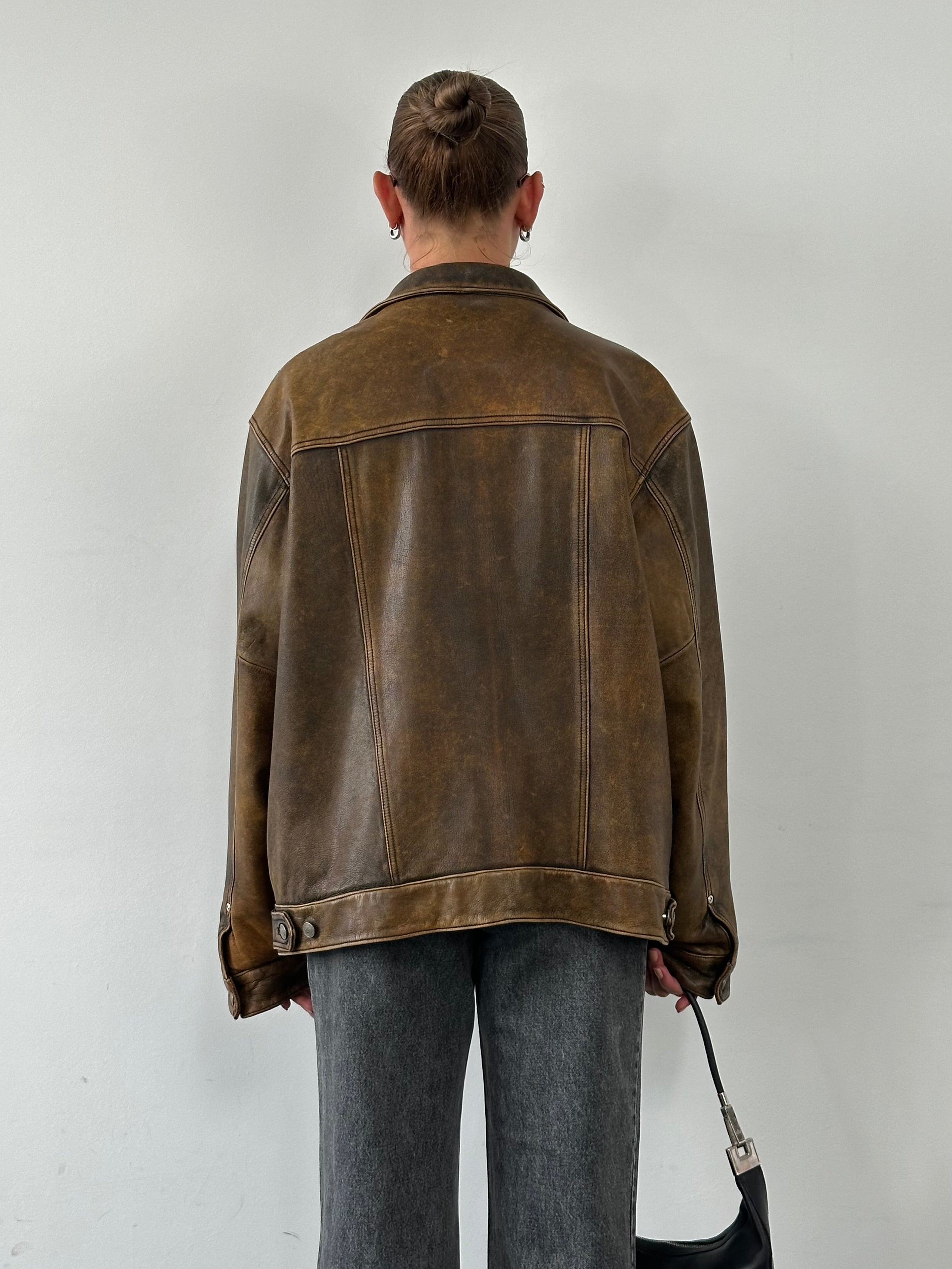 Vintage aged leather trucker jacket in XL with classic design, featuring rugged texture and sturdy construction, front view.