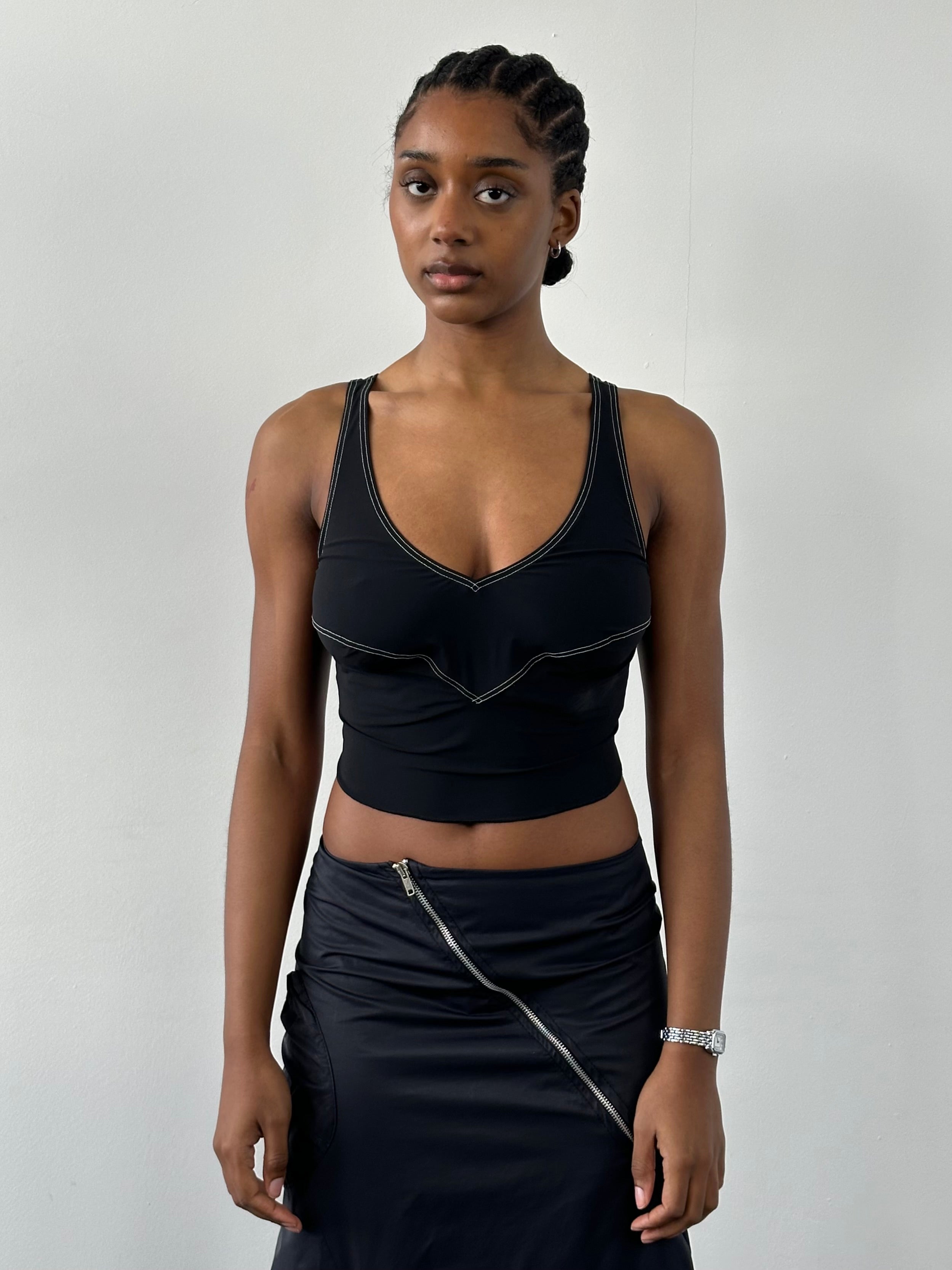 Vintage 2000s sleeveless contrast stitch tank top, casual style, in black with white stitching, displayed on a hanger.