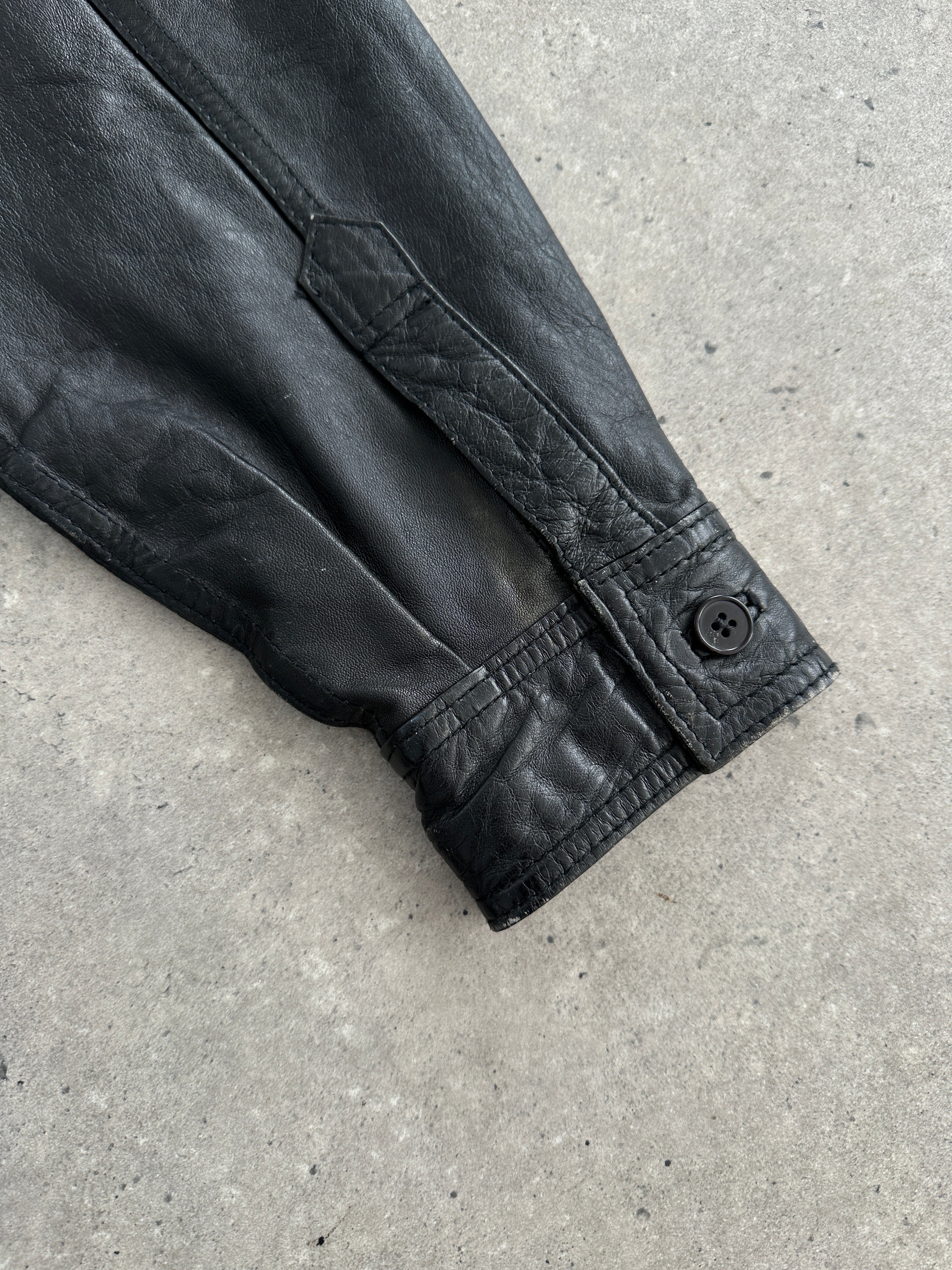 Vintage leather shirt in size L/XL, featuring classic design and rich texture, displayed on a hanger.