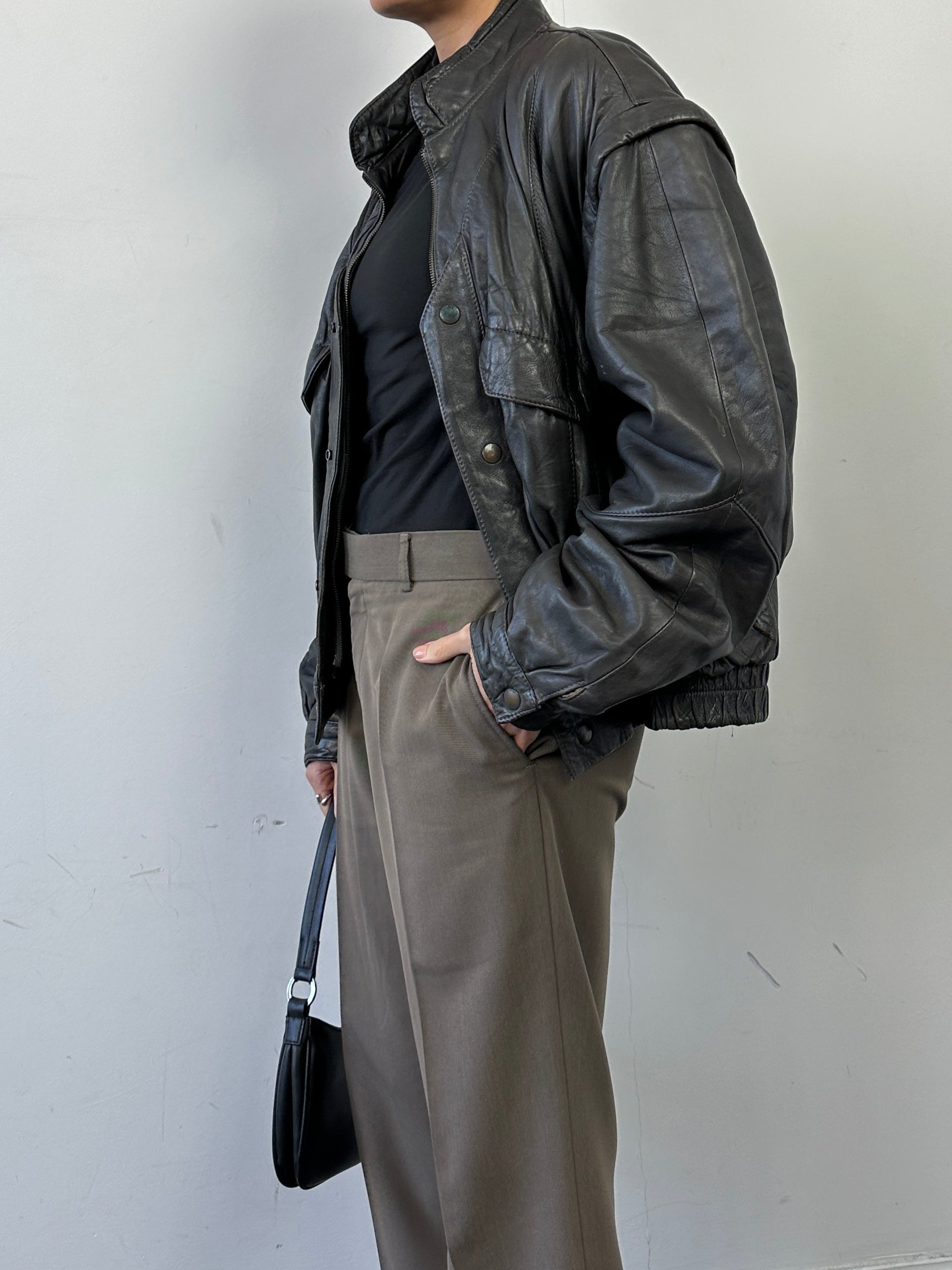 Vintage leather bomber gilet jacket in size M, featuring classic design and rich leather texture, displayed on a hanger.