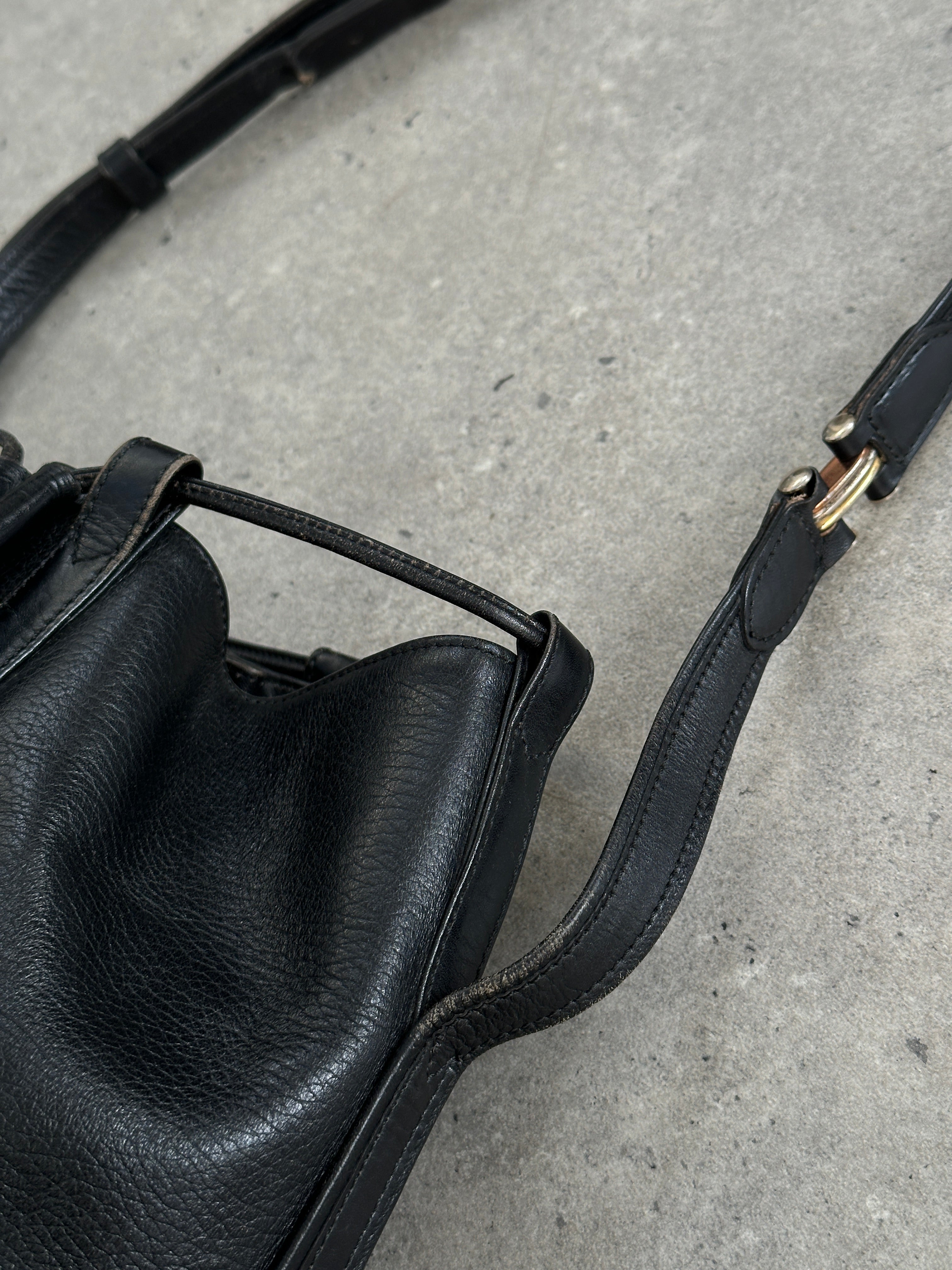 Cartier 1980s leather bucket bag with adjustable strap and classic design, featuring smooth leather finish and subtle branding.
