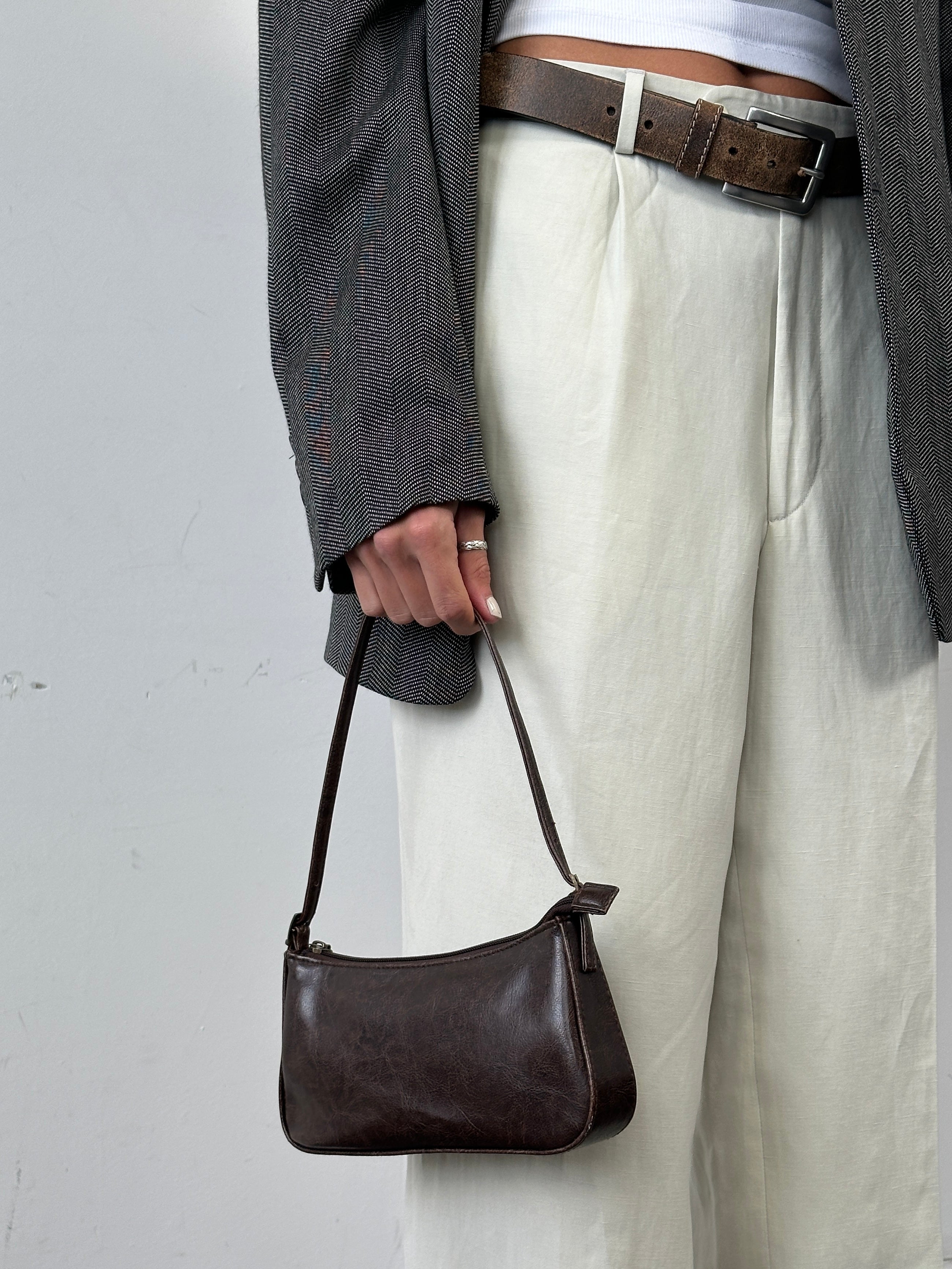 Vintage faux leather shoulder bag with adjustable strap, featuring a classic design and textured surface.