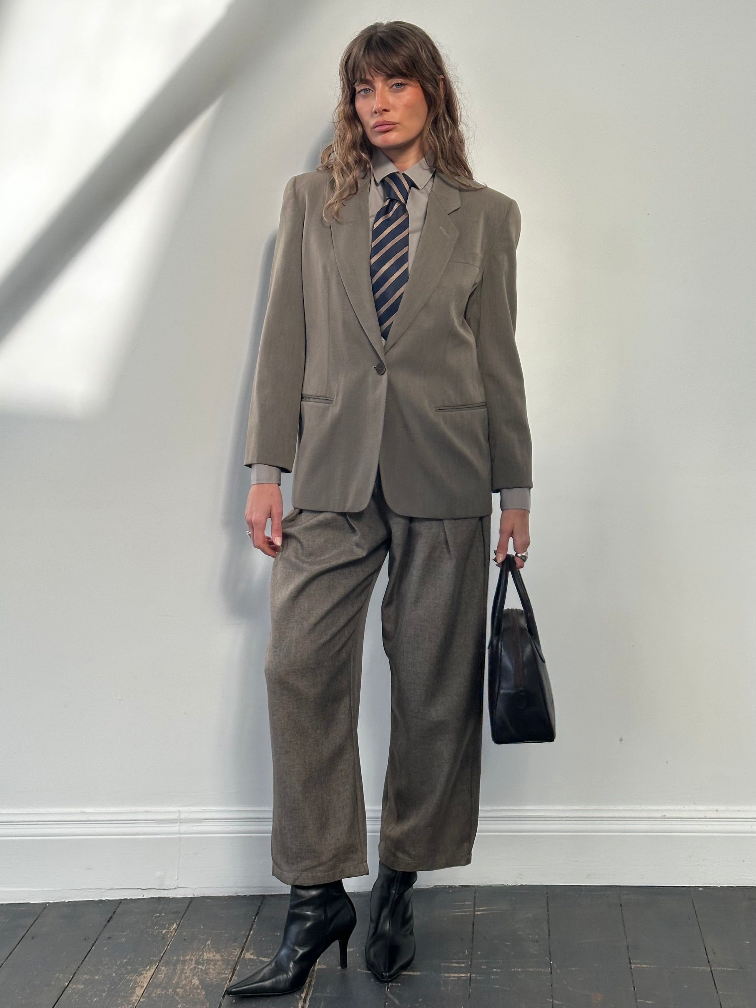 Mani 1990s wool tailored blazer with single button closure, slim fit, in classic dark color, displayed on a hanger.
