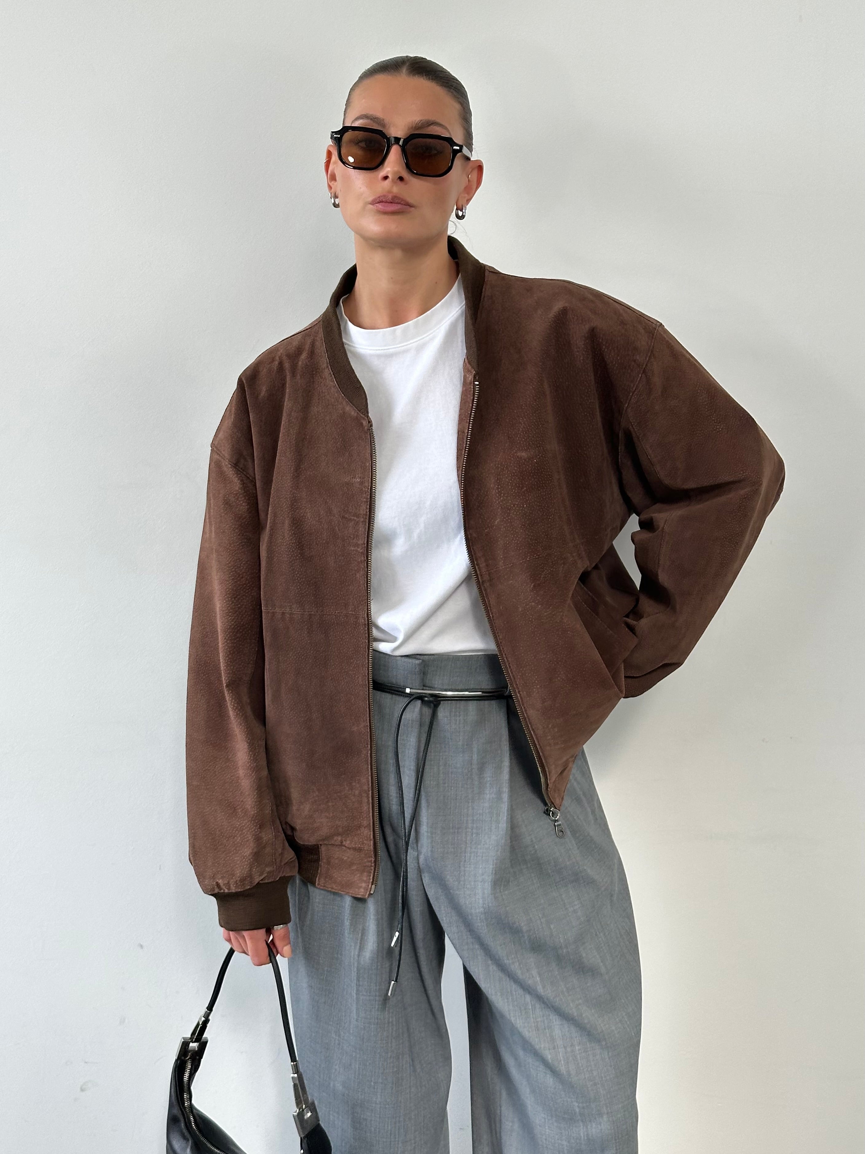 Vintage suede bomber jacket in XL/XXL, showcasing its classic design and soft textured material on a hanger.
