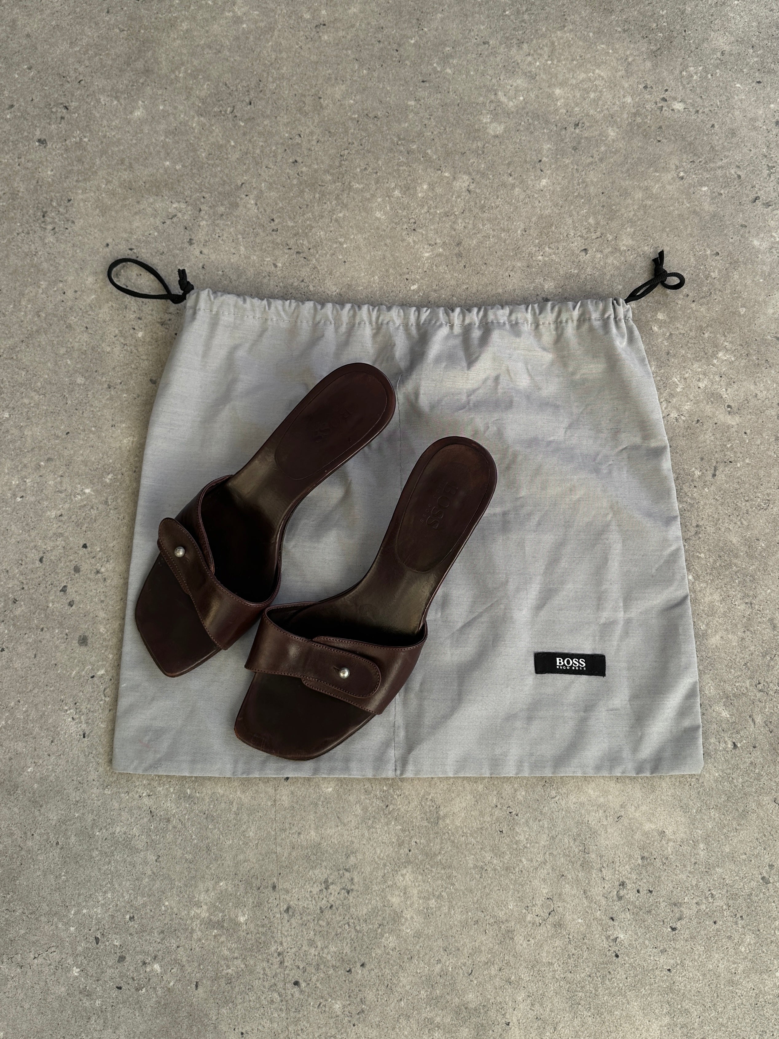 Hugo Boss leather mules in UK size 5, stylish slip-on shoes with sleek design and neutral color.