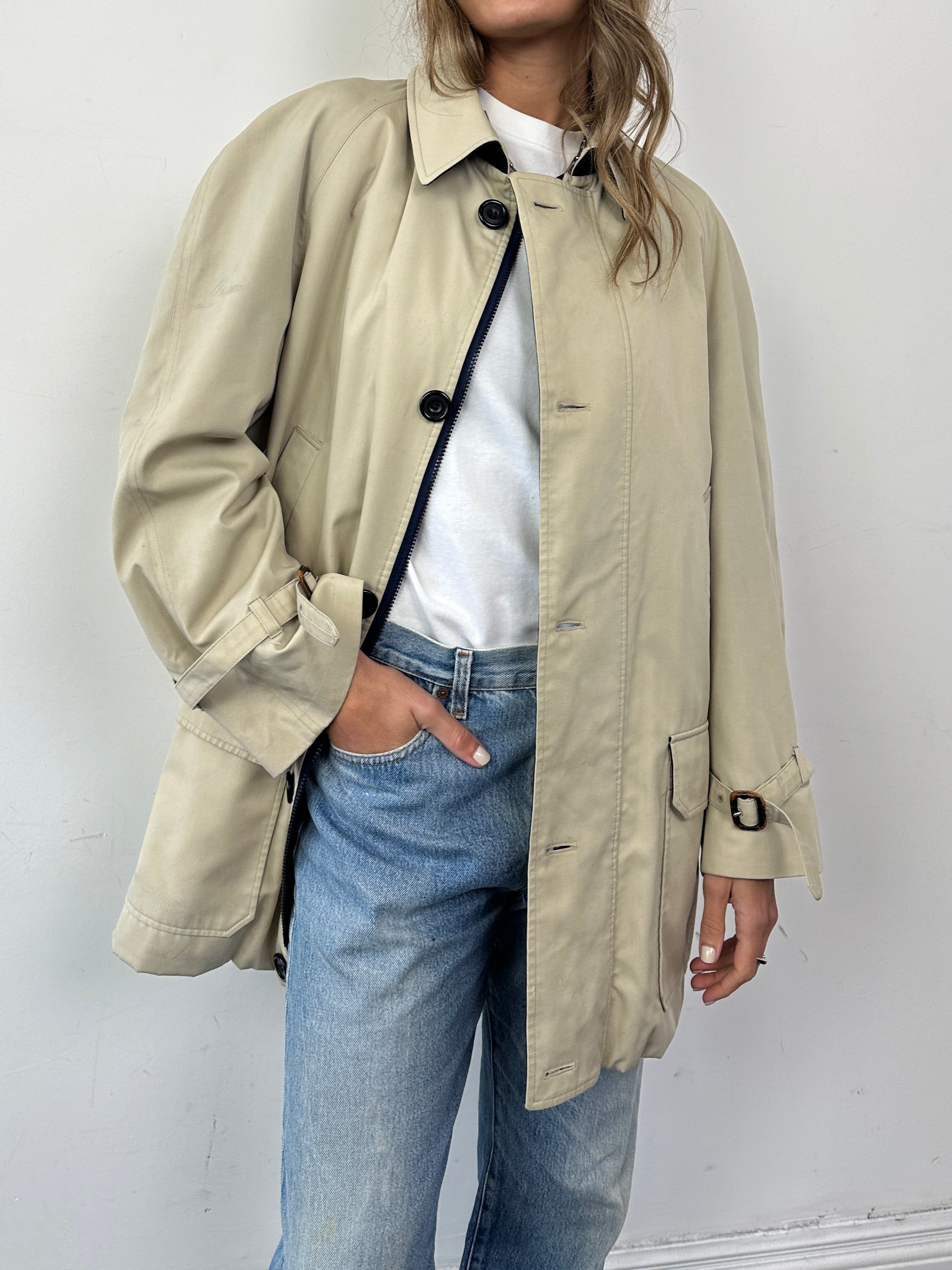 Aquascutum wool-lined mid-length coat in XL displayed on a hanger, featuring a classic design and tailored fit.