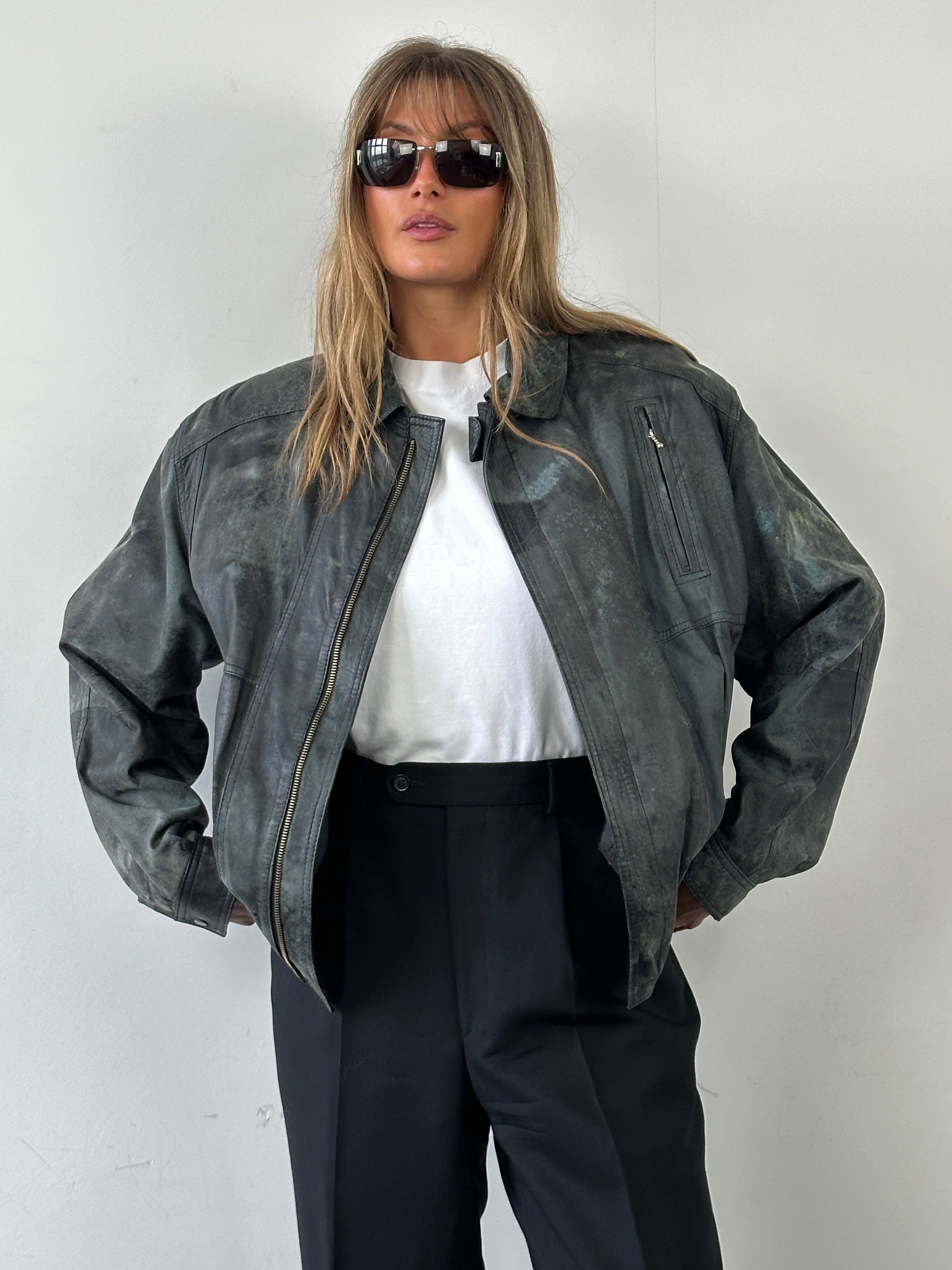 Vintage distressed marbled leather jacket in size M, featuring rugged texture and classic style, displayed on a hanger.