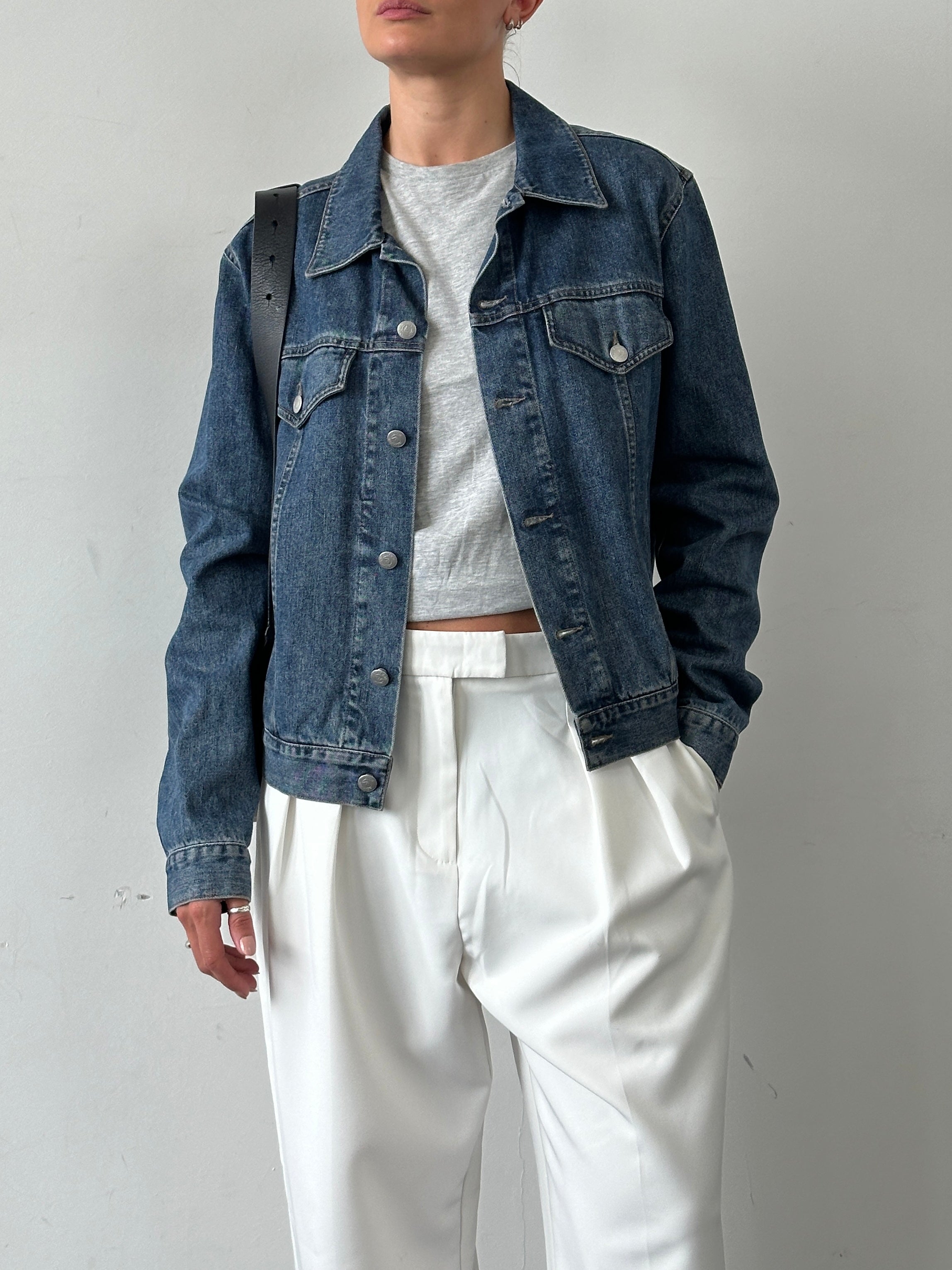 Armani Jeans denim jacket in size M with classic blue wash and button-front design, displayed on a hanger.