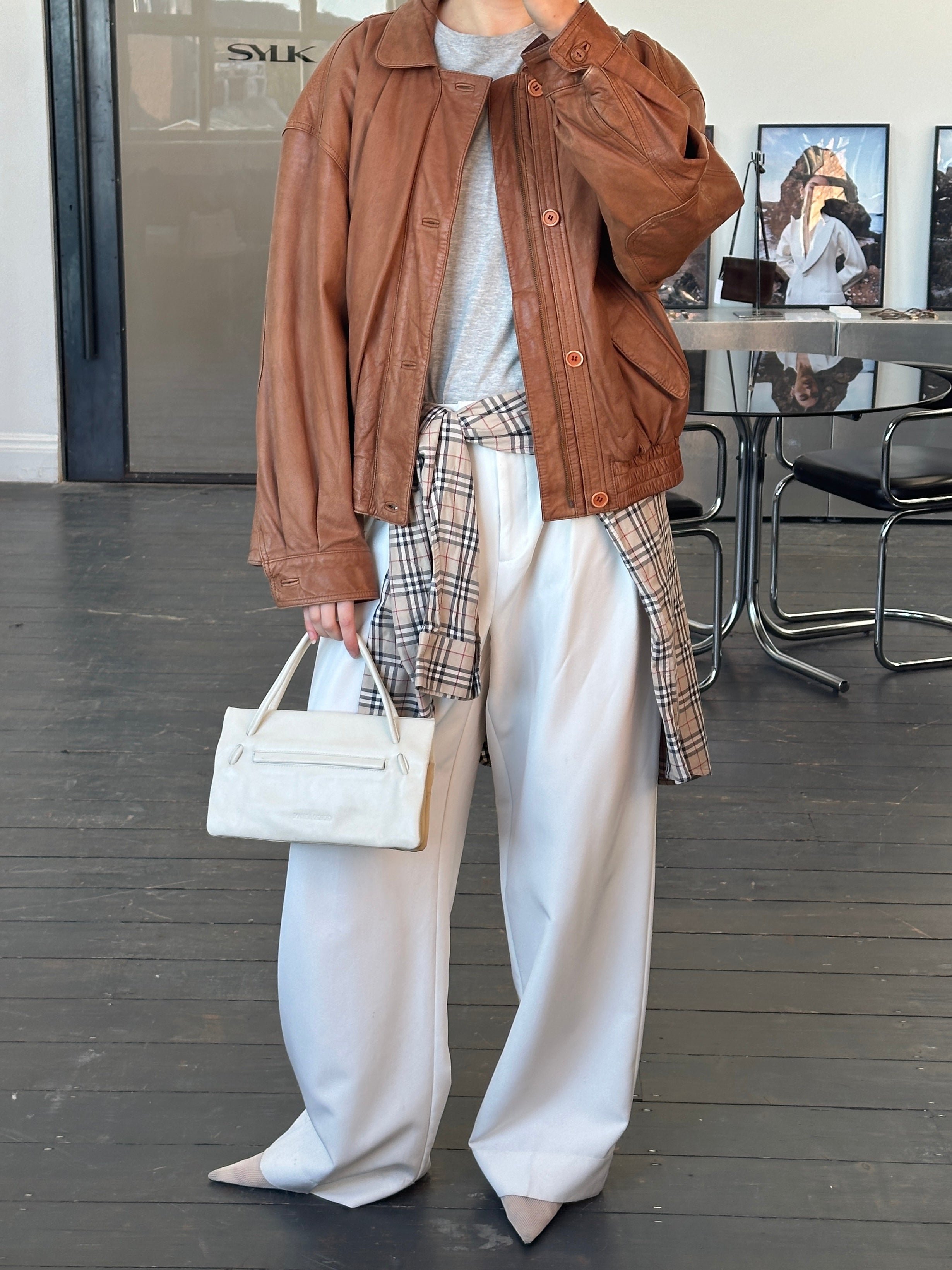 Vintage 1980s leather bomber jacket in size large, featuring classic style and worn leather texture.