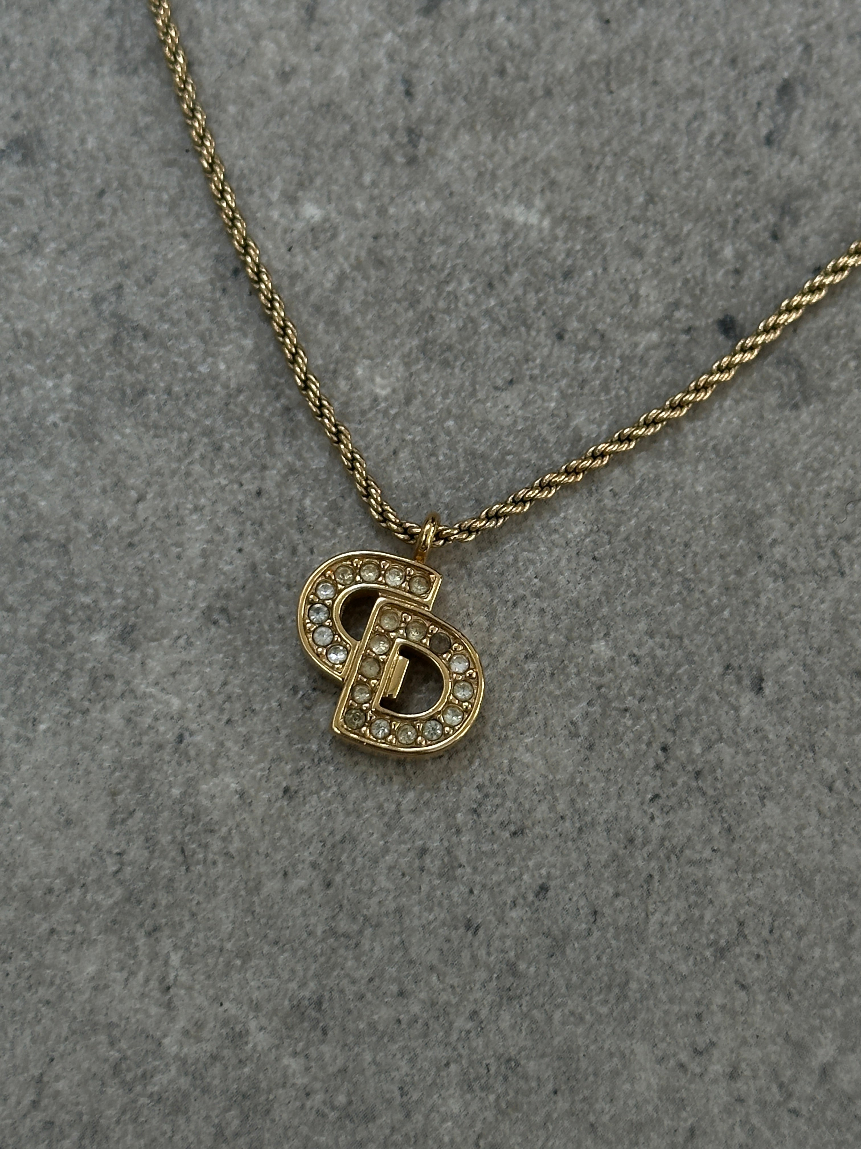 Christian Dior 16-inch gold plated rhinestone logo pendant necklace showcasing a sparkling logo pendant on a delicate chain