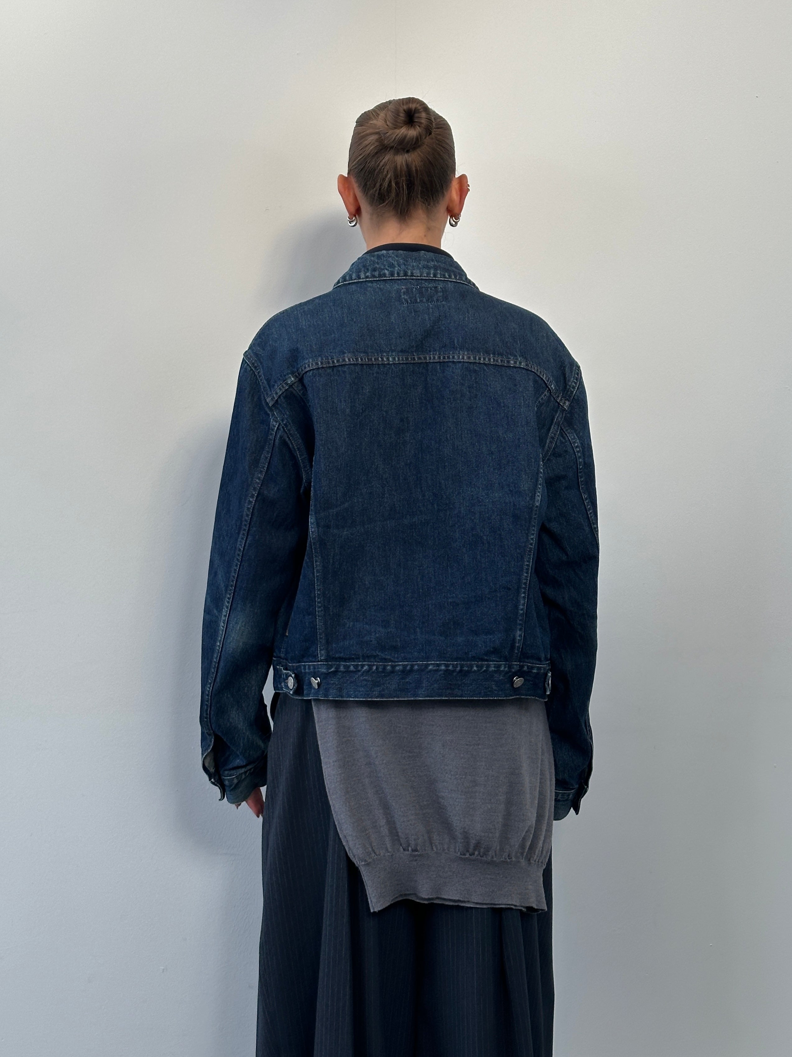 Armani Jeans 1900s mid wash denim jacket hanging on a hanger, showing front view with classic collar and button closure.