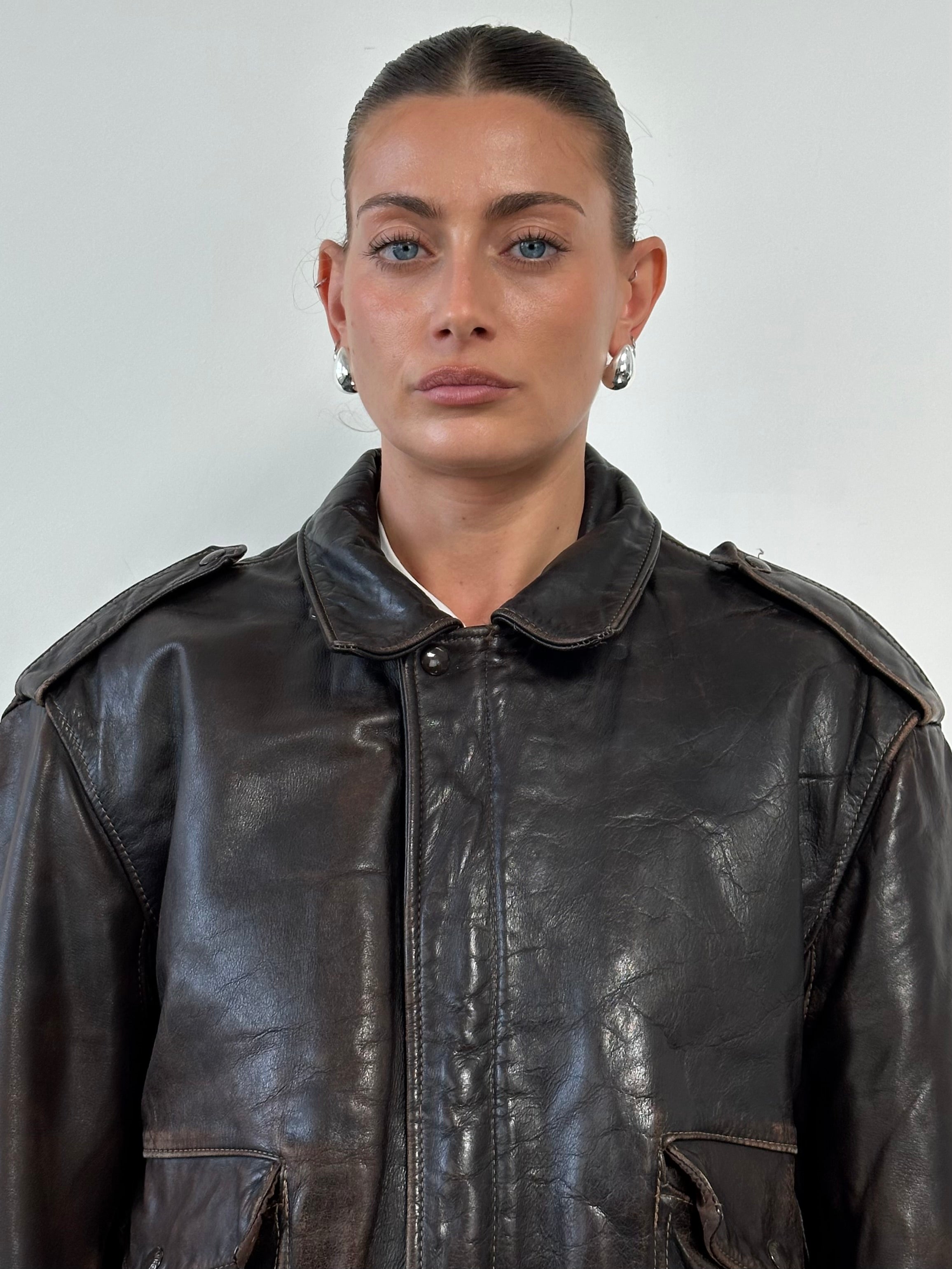 Schott NYC distressed leather bomber jacket in size L/XL, featuring a rugged design with visible wear and classic style.