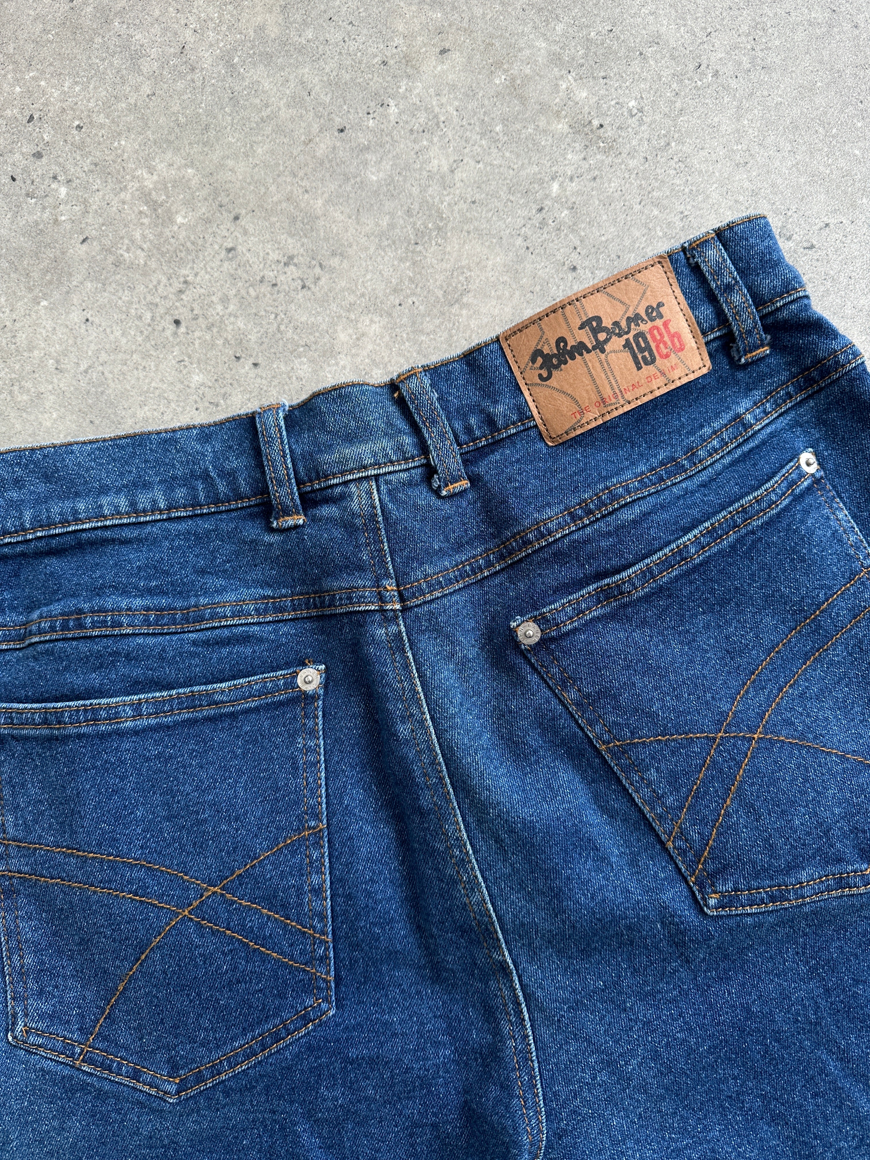 Vintage high-waisted straight-leg denim jeans in W32 with classic blue wash, displayed on a wooden background.