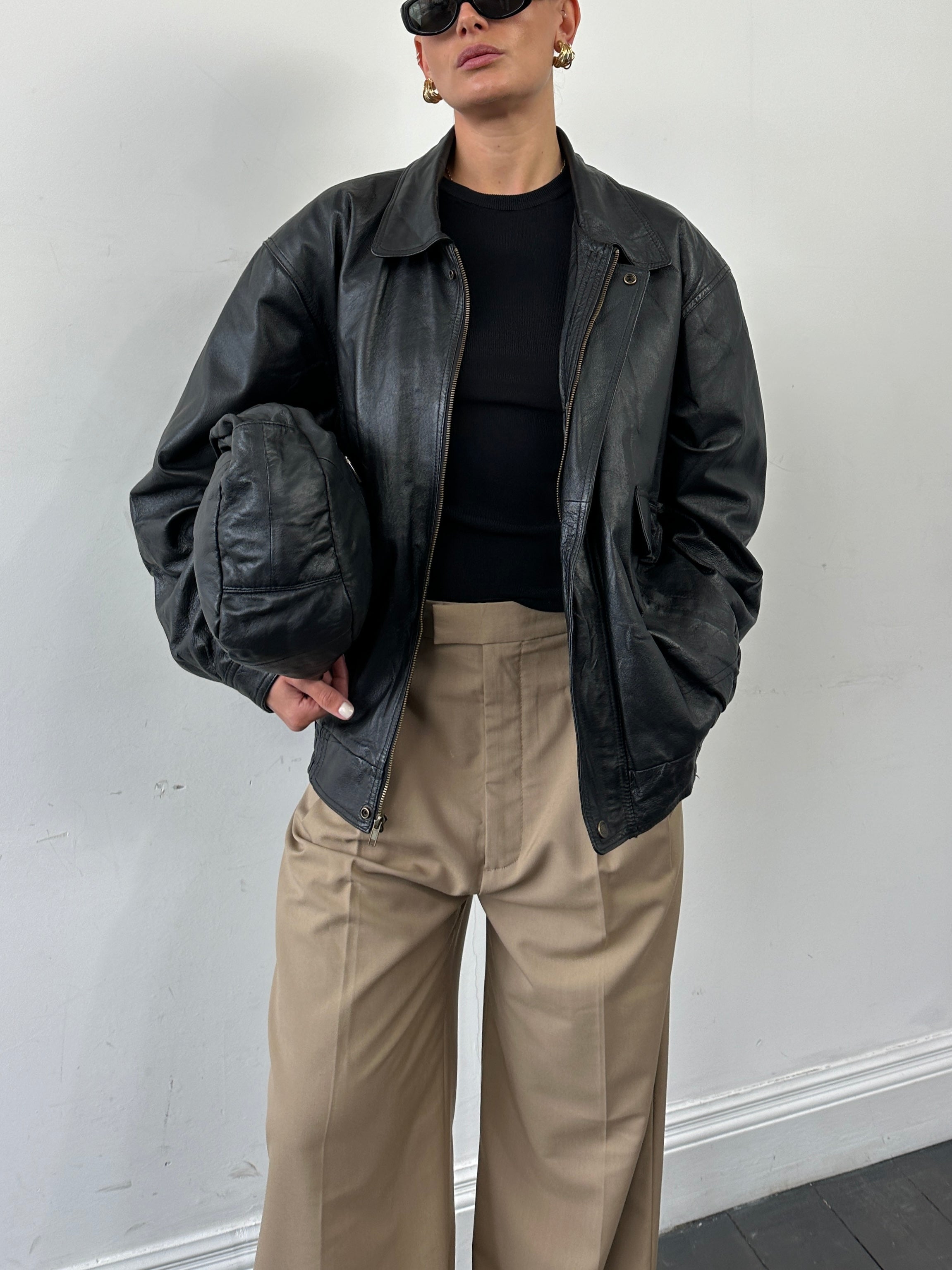 Vintage leather bomber jacket in XL size, featuring classic design, distressed leather, and ribbed cuffs and collar.