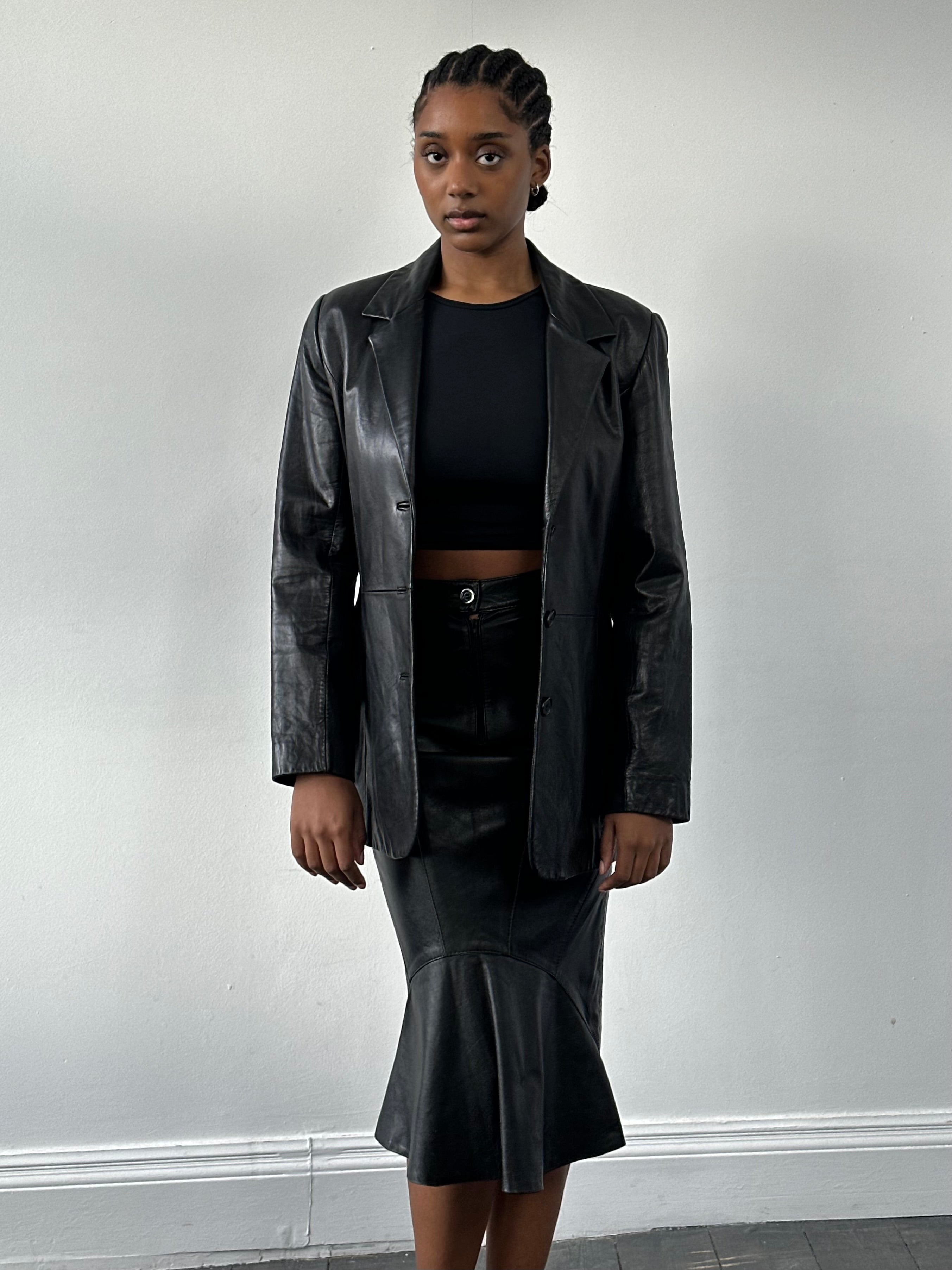 Vintage 1990s leather midi skirt, W25, featuring a classic A-line design and rich brown leather fabric.