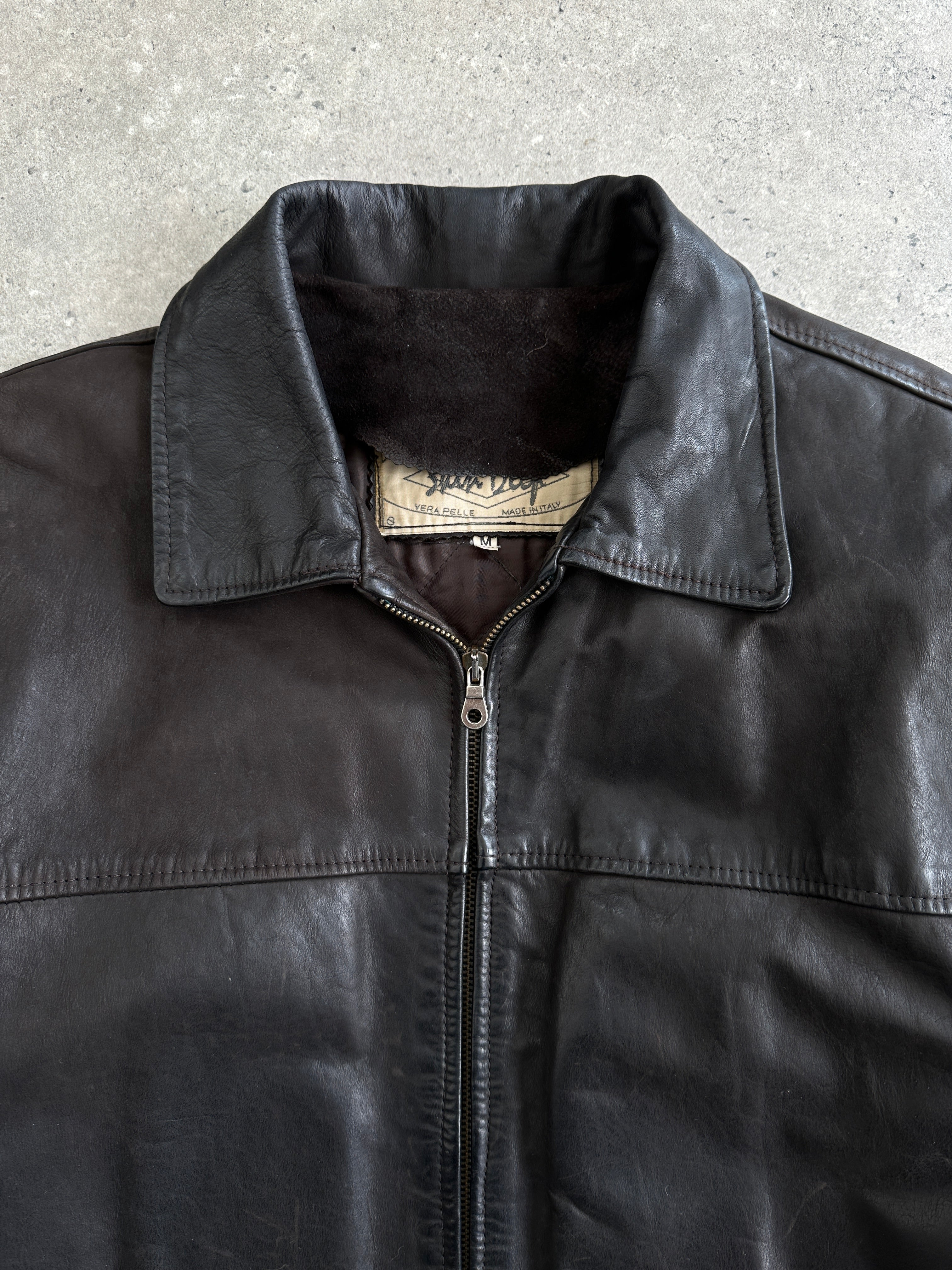 Italian Vintage Leather Jacket in size L, featuring classic craftsmanship and aged leather, displayed on a hanger.