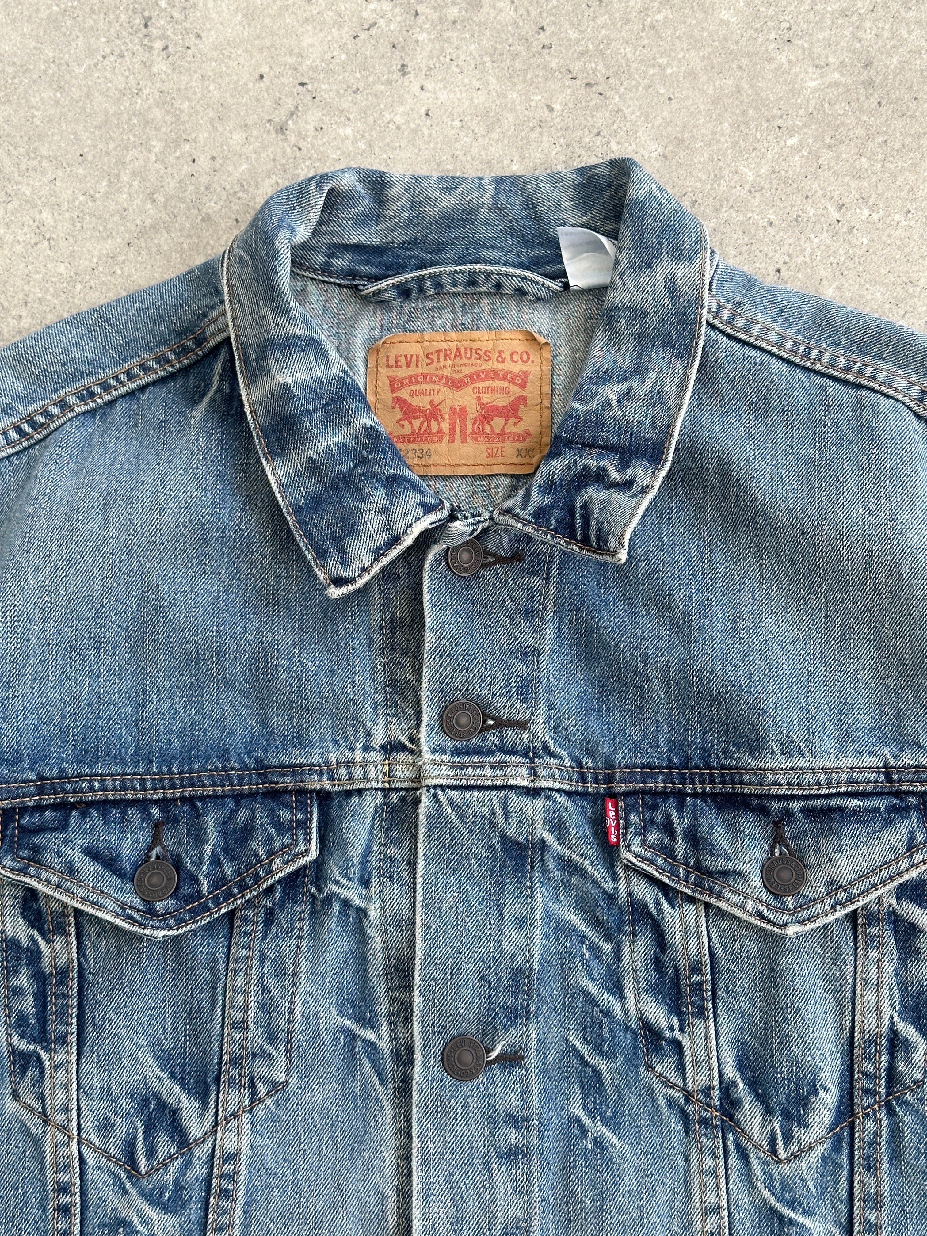 Levi’s 2000s light wash denim jacket in XL size, featuring classic fit and button-up front on a hanger.