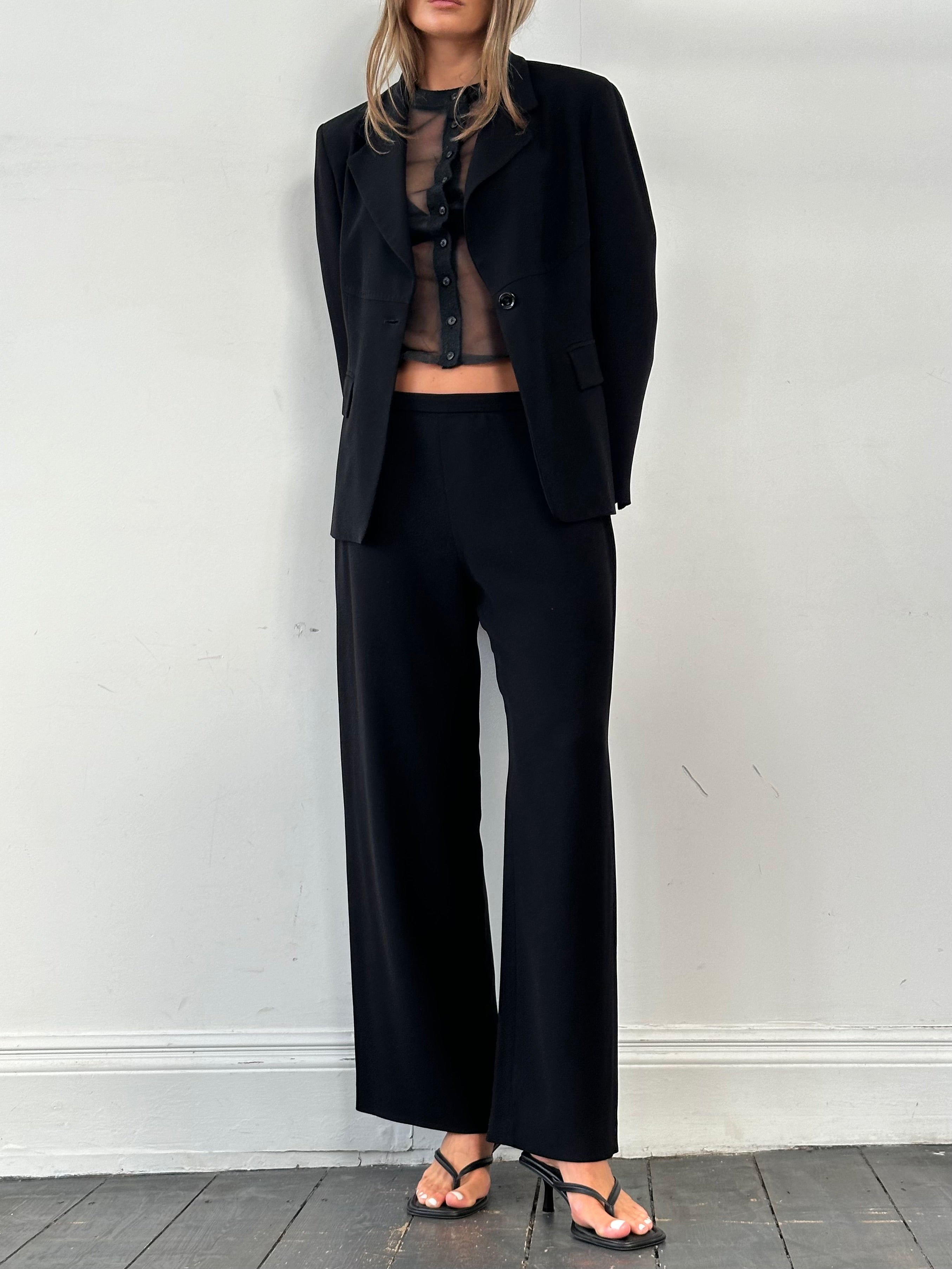 Max Mara minimal single-breasted jumpsuit in sleek fabric, shown on a hanger with clean lines and tailored fit.