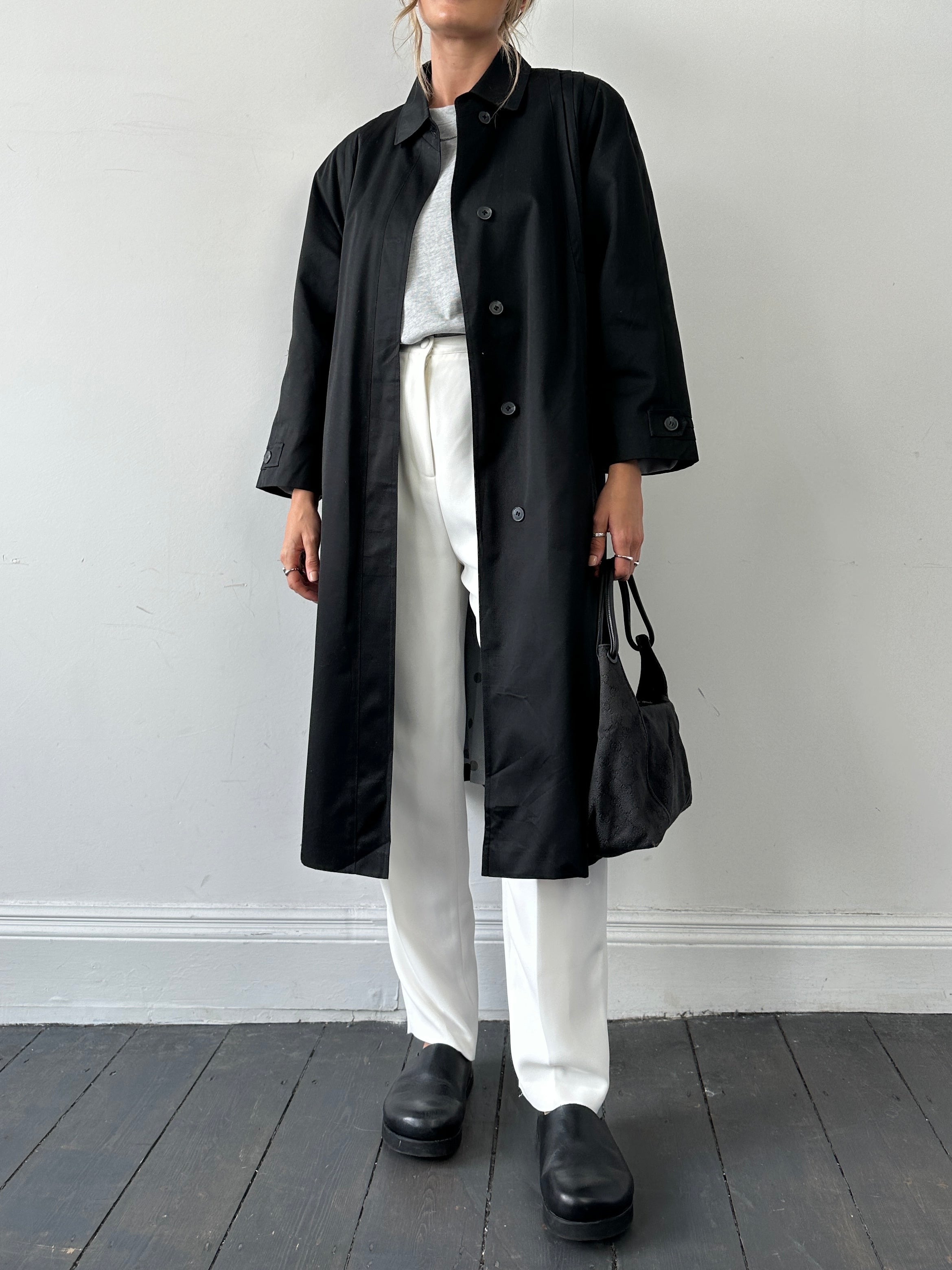 Vintage vintage-style pleated cotton trench coat in size M displayed on a hanger, showcasing classic design and fabric details.