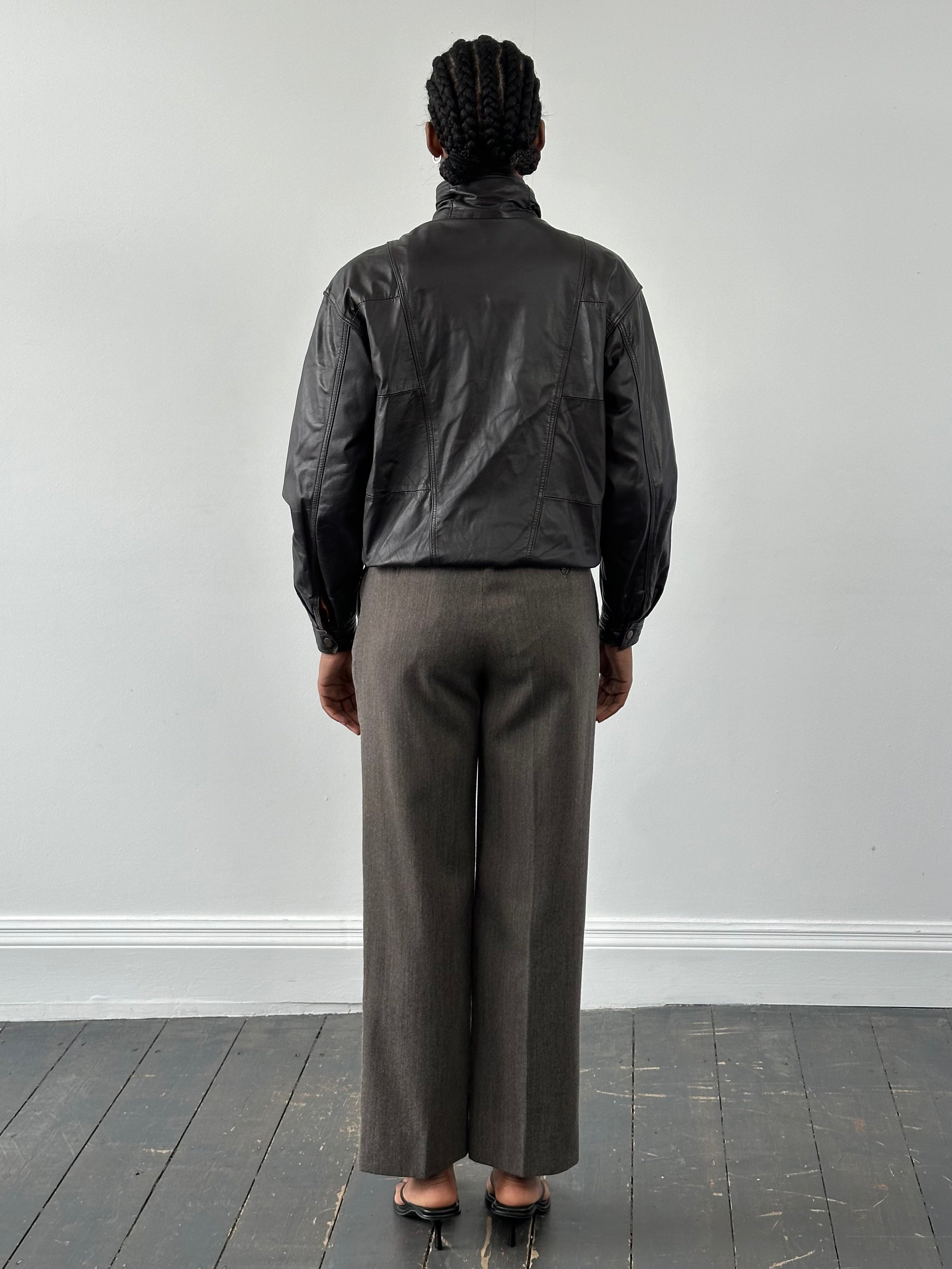 Valentino 1990s high neck leather bomber jacket in black with ribbed cuffs and collar, front zipper closure, and sleek design.