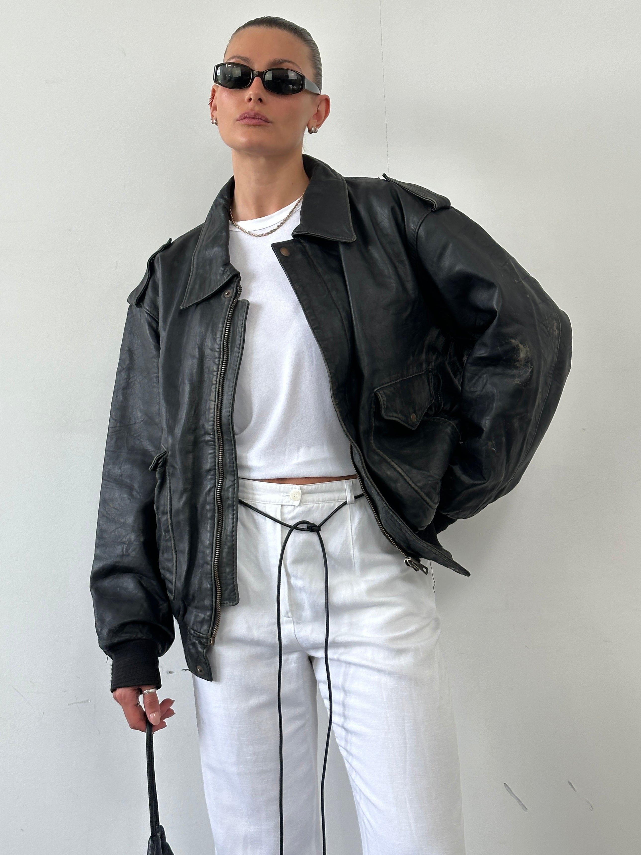 Vintage distressed leather bomber jacket in XL size, featuring rugged texture and classic style.