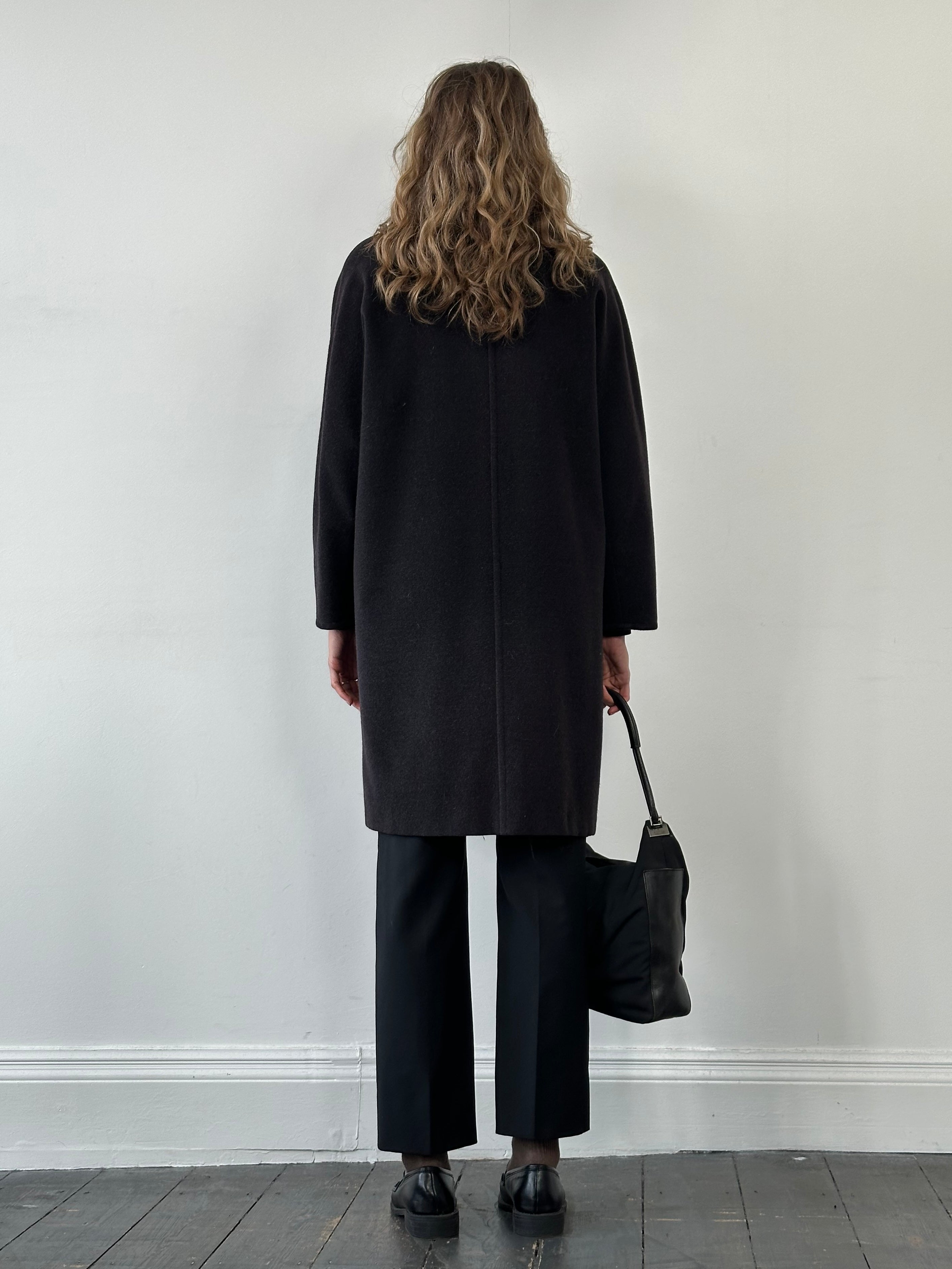 Max Mara pure wool double-breasted coat in size M, shown hanging on a wooden hanger with a tailored fit and classic design