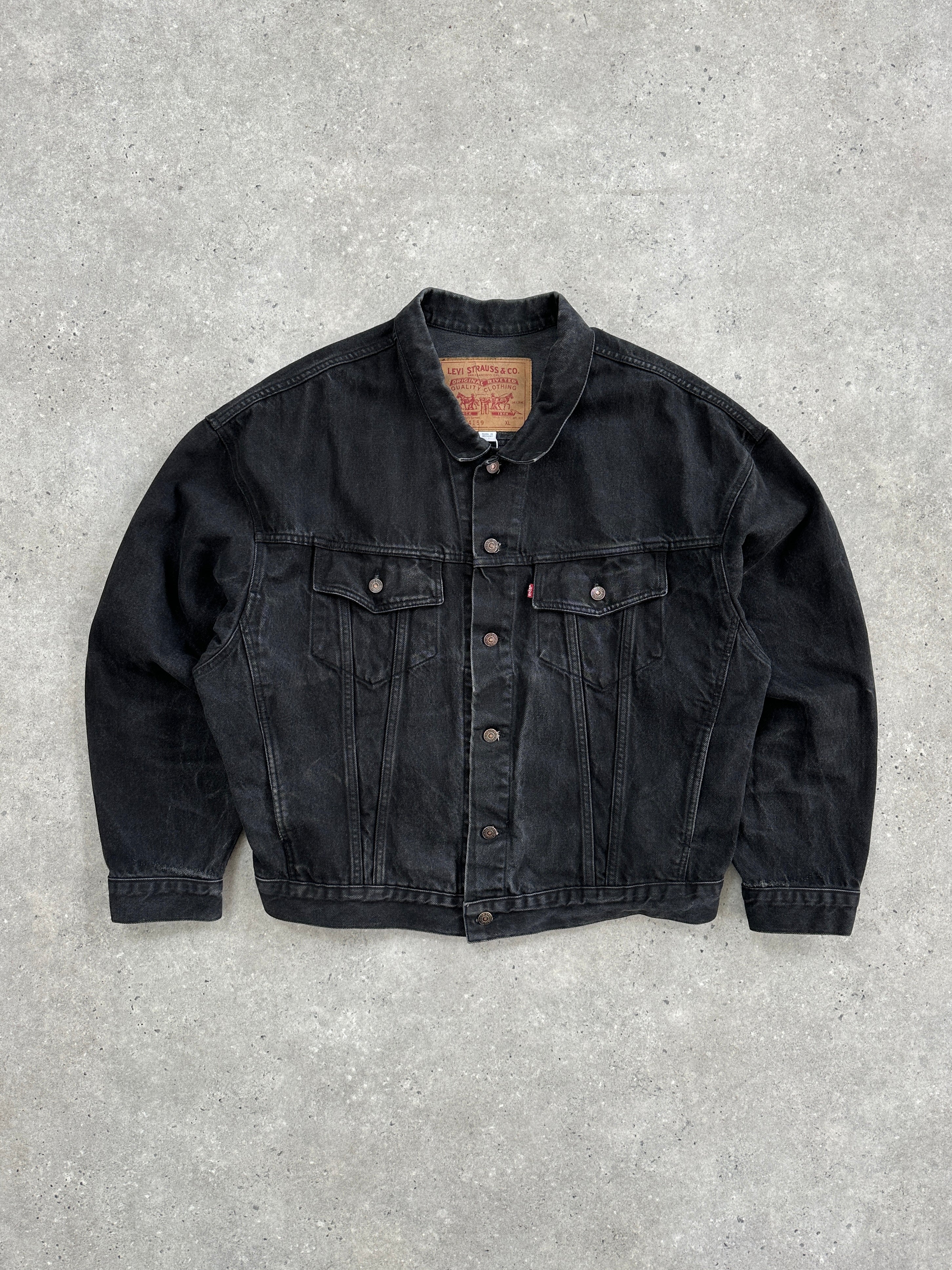 Levi’s 1990s washed denim jacket in XXL displayed on a hanger, showing classic distressed blue denim with button front and collar