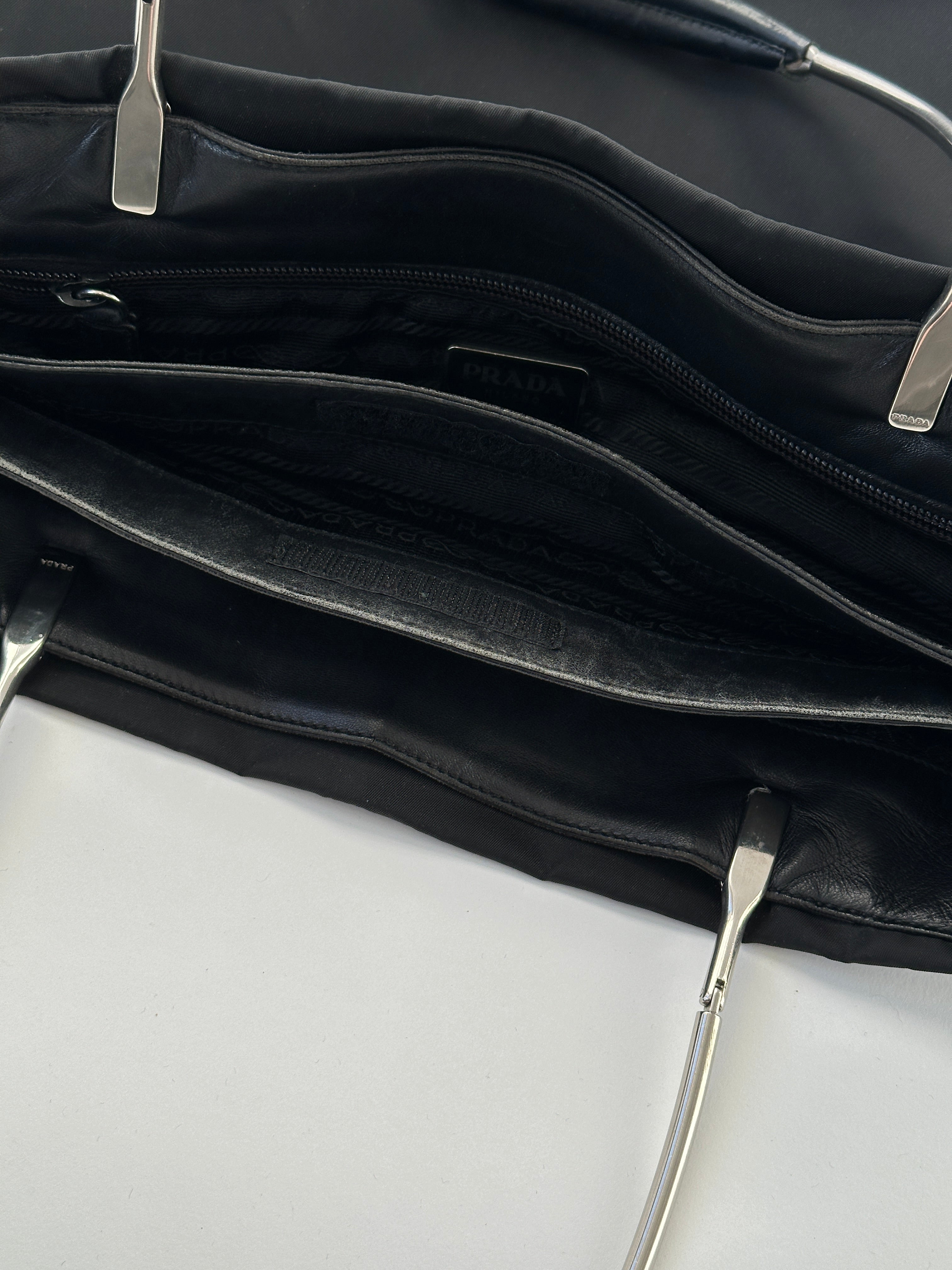 Prada nylon leather tote bag with sleek design, featuring sturdy handles and spacious interior for everyday use.