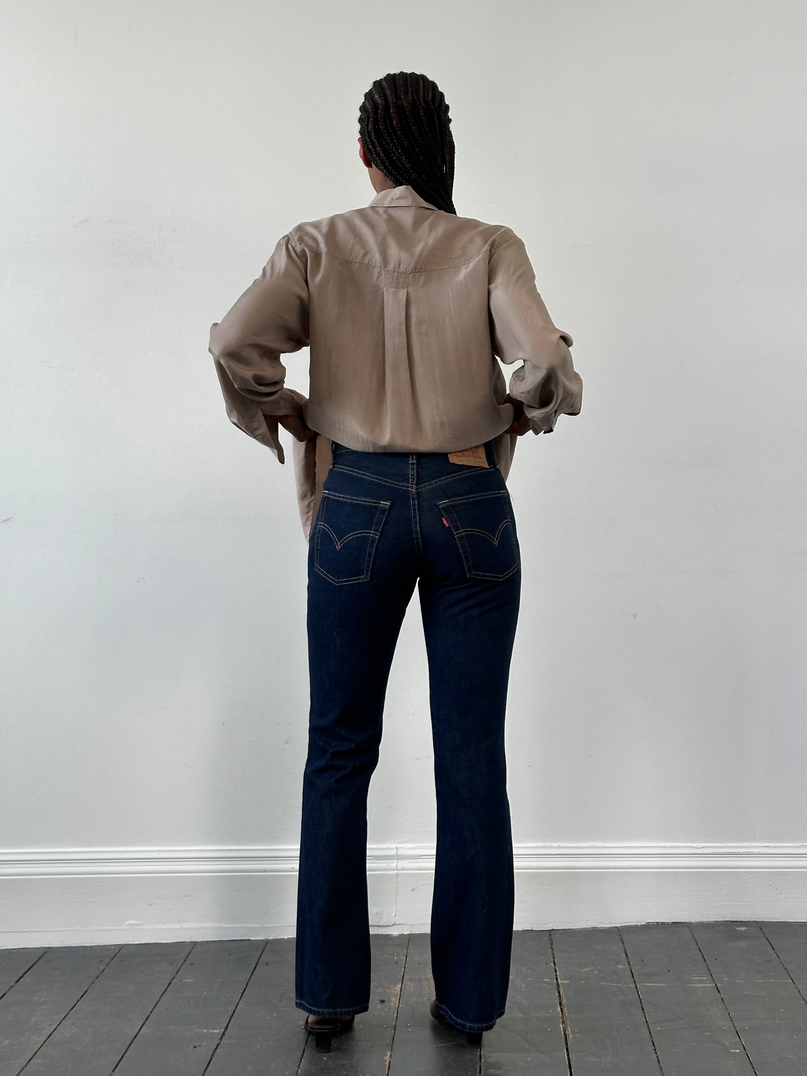 Levi’s 525 mid-rise denim bootcut jeans in dark wash, W26, displayed on a hanger with front and back views.