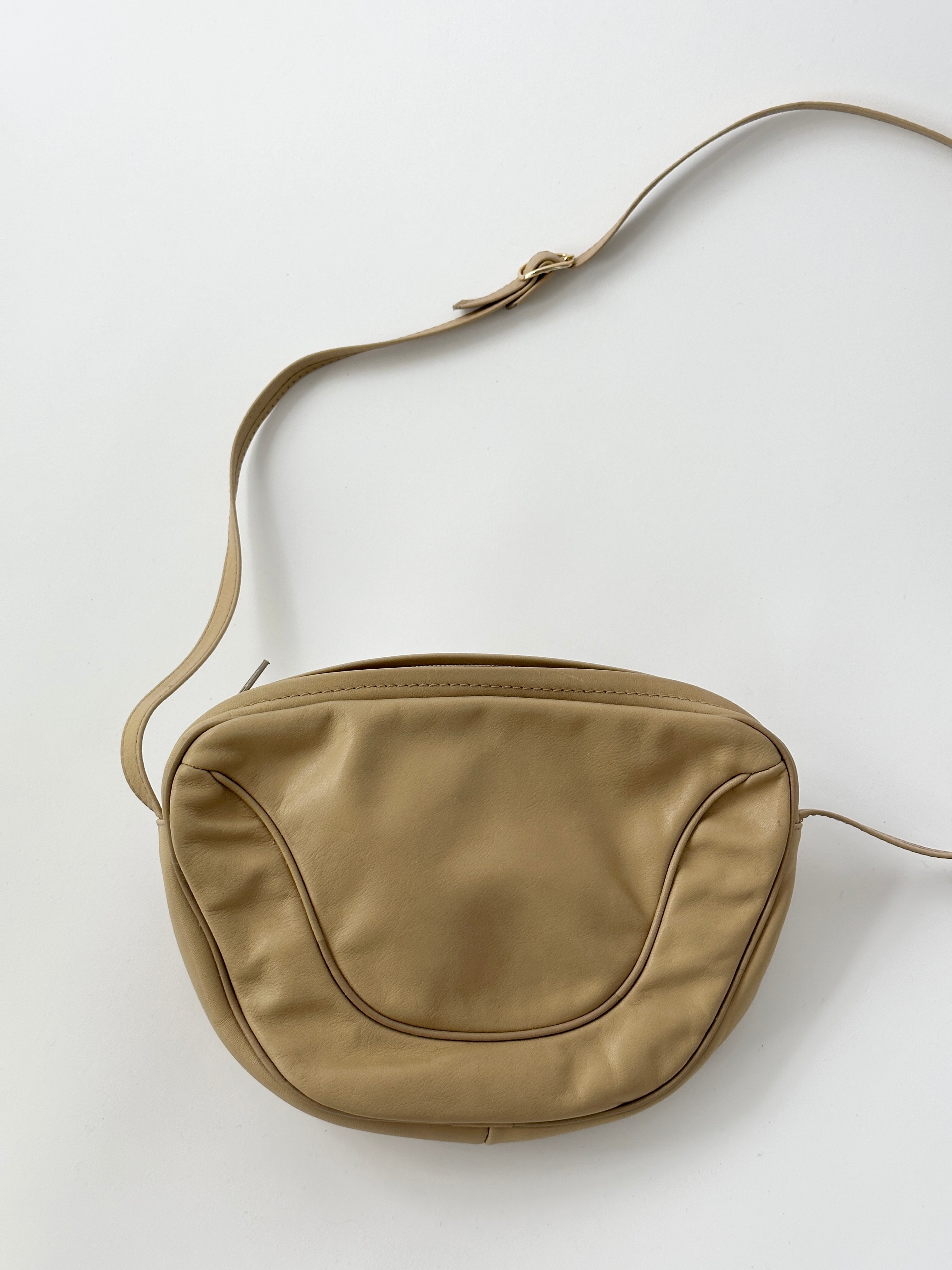 Vintage faux leather crossbody bag with adjustable strap and classic design, featuring a sleek, textured finish.