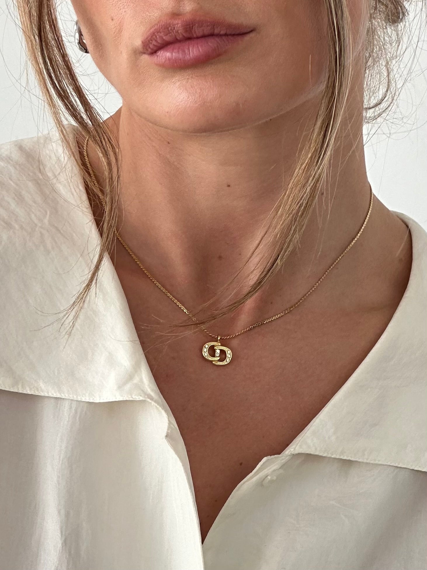 Christian Dior 16-inch gold plated rhinestone logo pendant necklace with Christian Dior branding and elegant design.