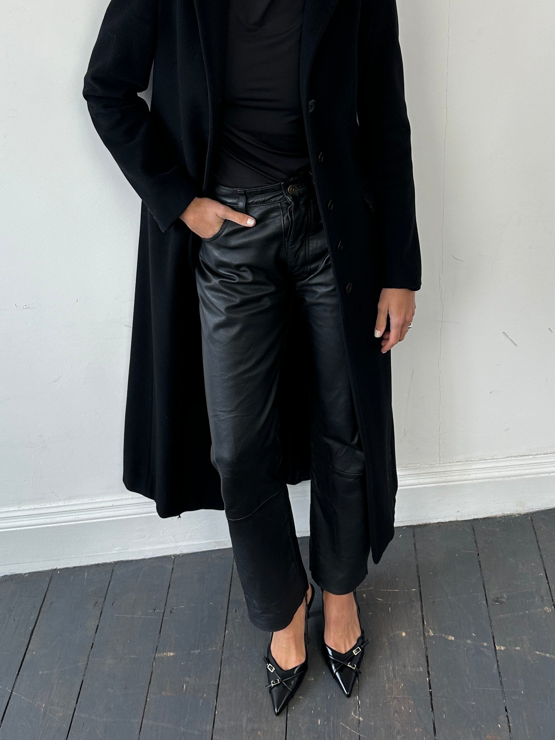 Vintage straight-leg leather trousers in size W30, showcasing their classic fit and smooth leather texture.