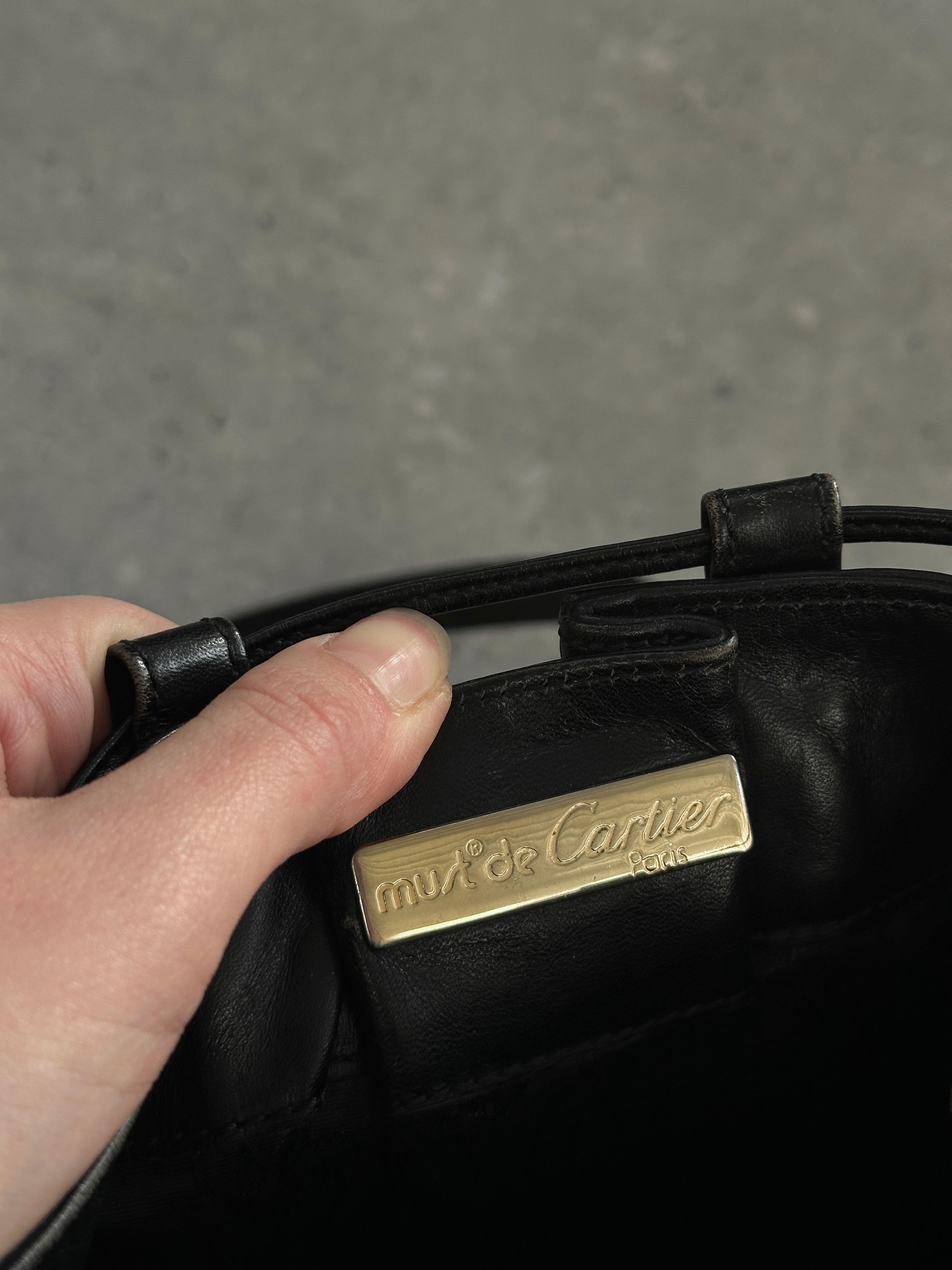 Cartier 1980s leather bucket bag featuring a rounded shape, adjustable strap, and classic luxury design.