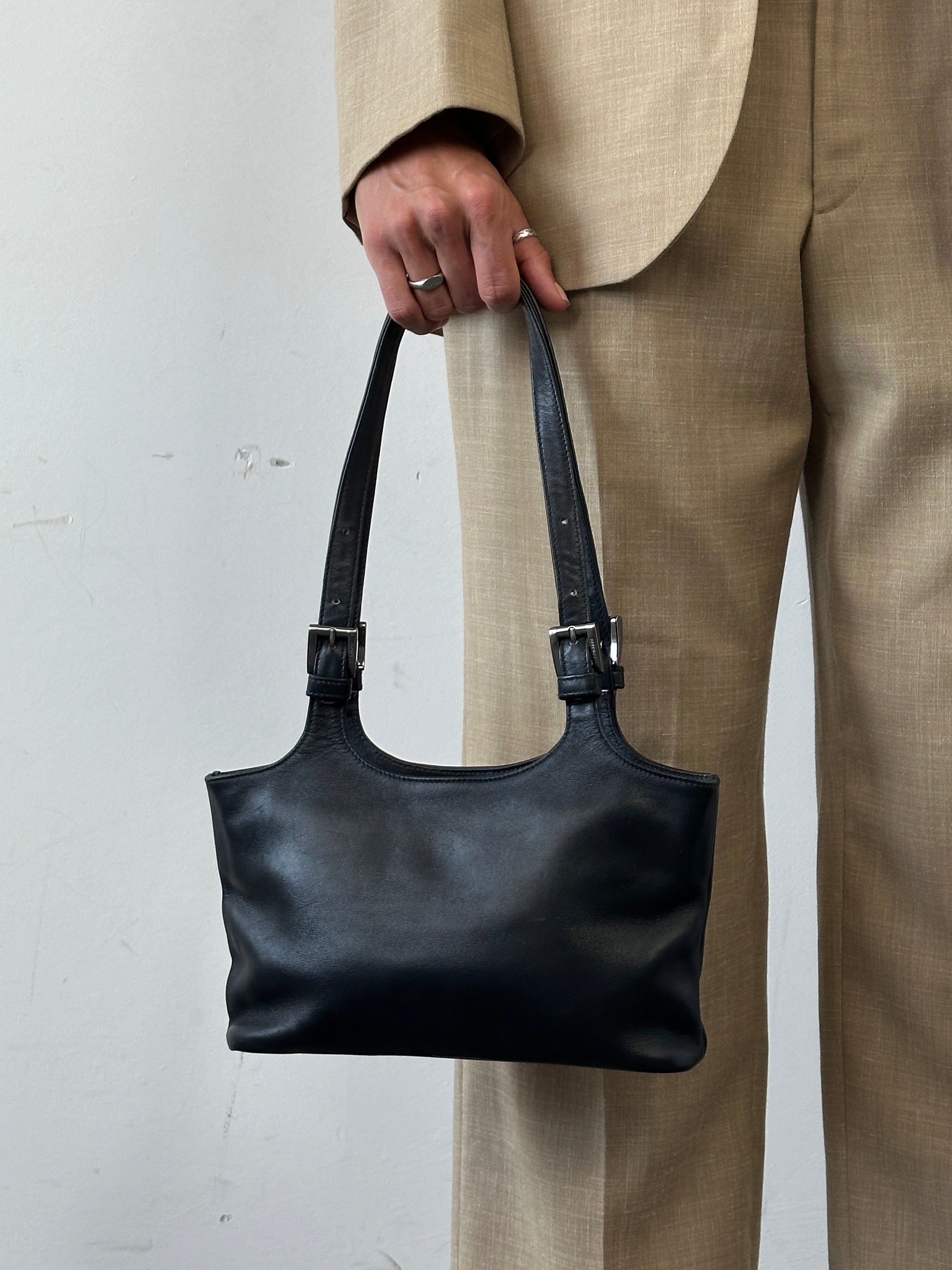 Vintage Italian leather shoulder bag with buckle closure, showcasing classic craftsmanship and stylish design.