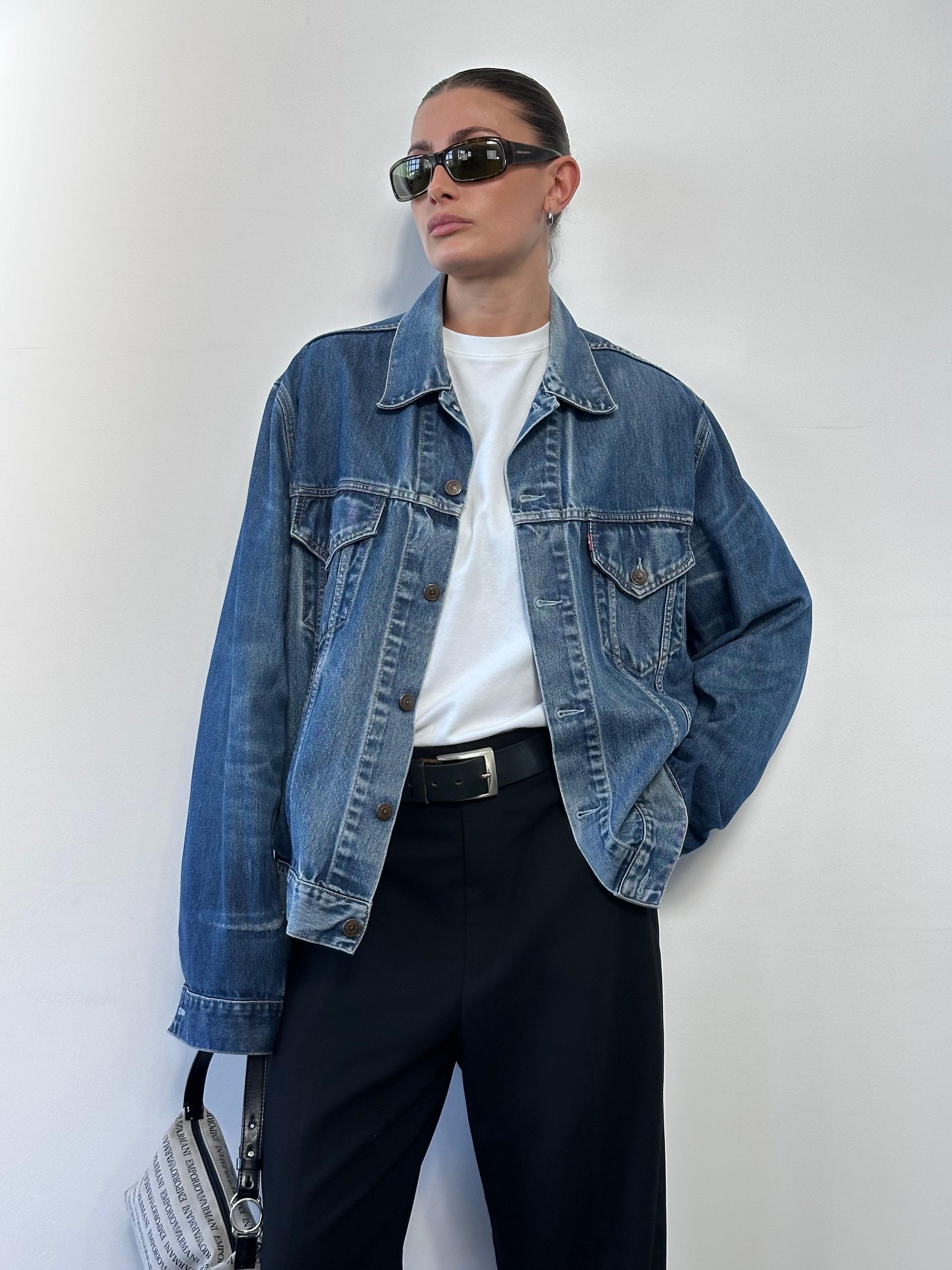 Levi’s faded denim jacket in size L with classic button closures and distressed look, shown on a hanger.