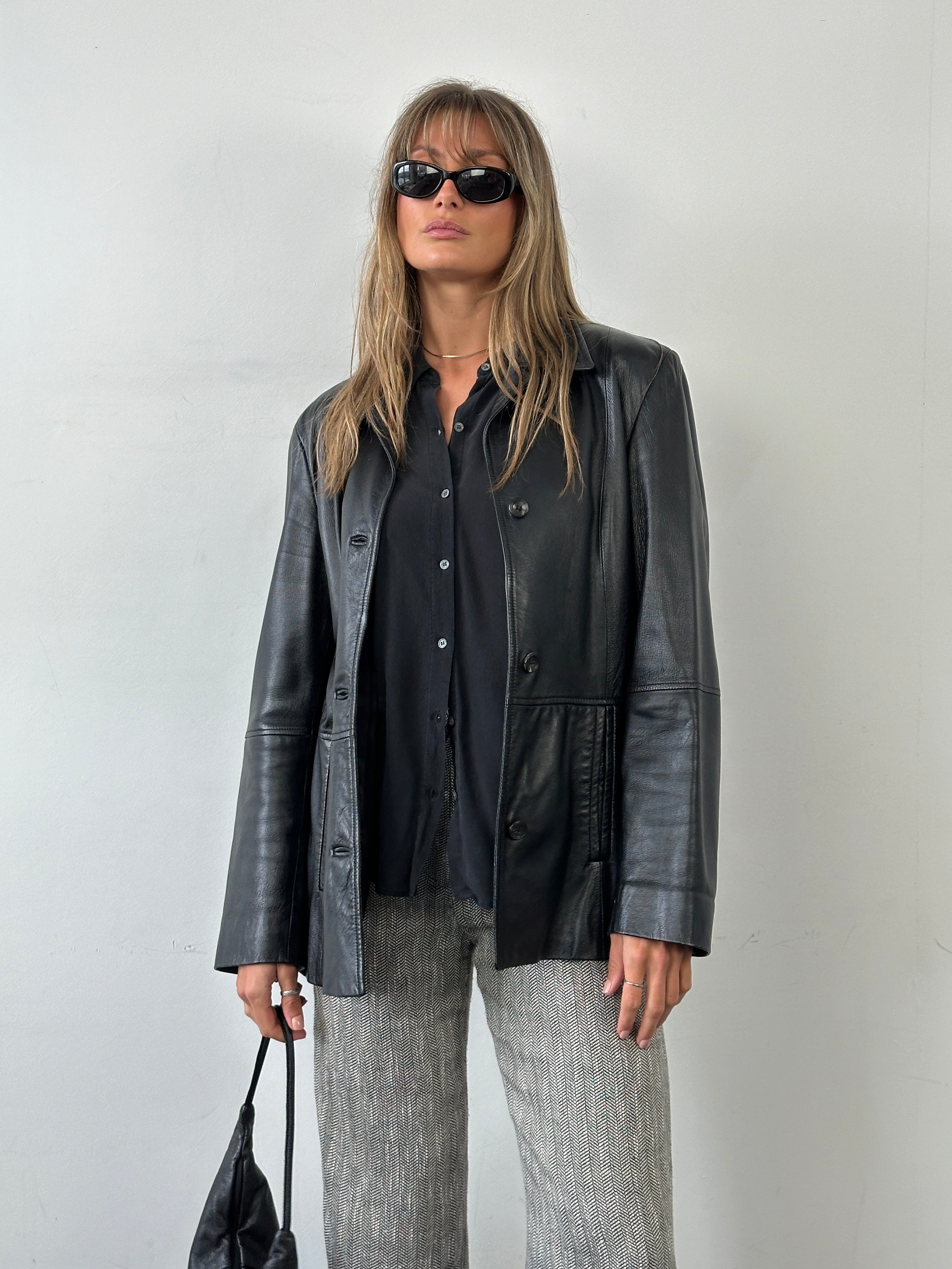 Marella smooth leather jacket in size M displayed on a hanger with a sleek, fitted design and classic collar.