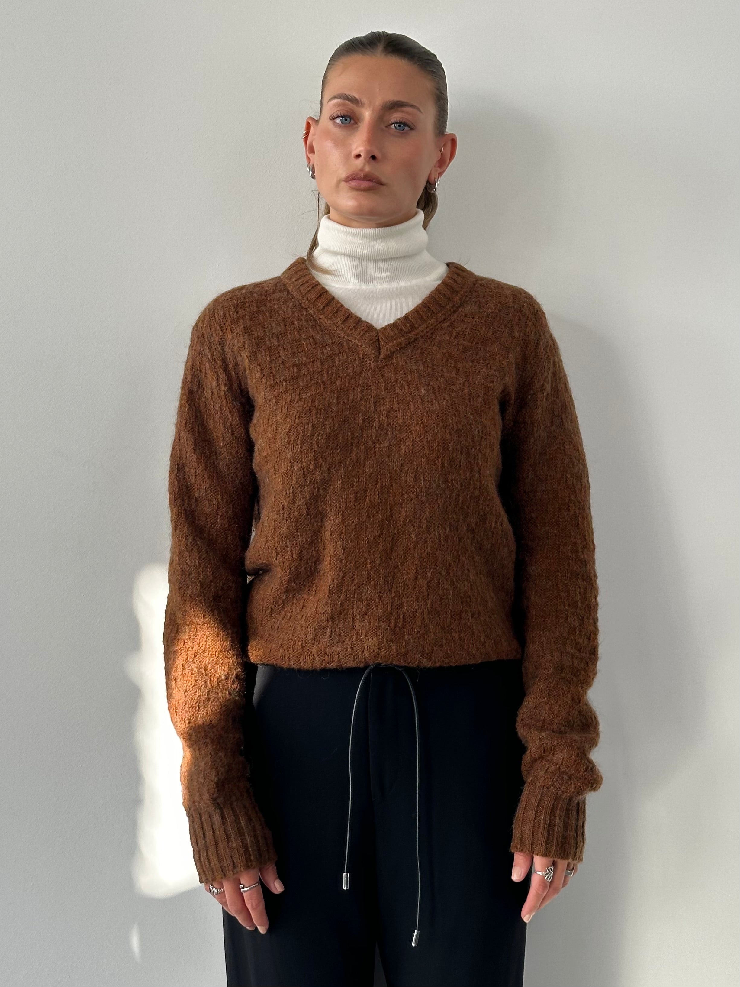 Vintage Italian wool V-neck knitted jumper in size M, featuring classic knit pattern and cozy wool texture.