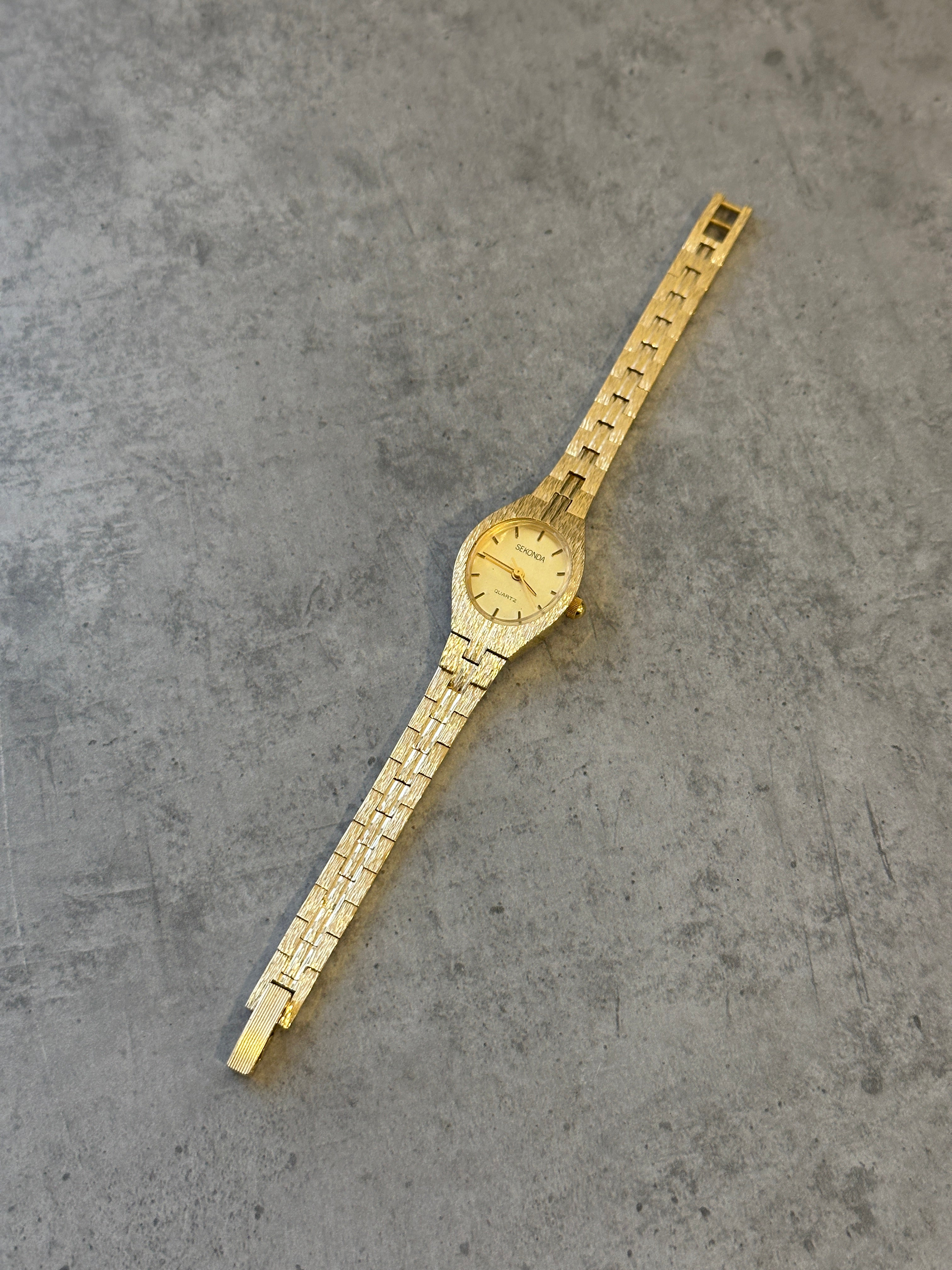 Sekonda 1990s gold-tone quartz watch with a classic round dial and metal bracelet, showcasing vintage style and elegant design.