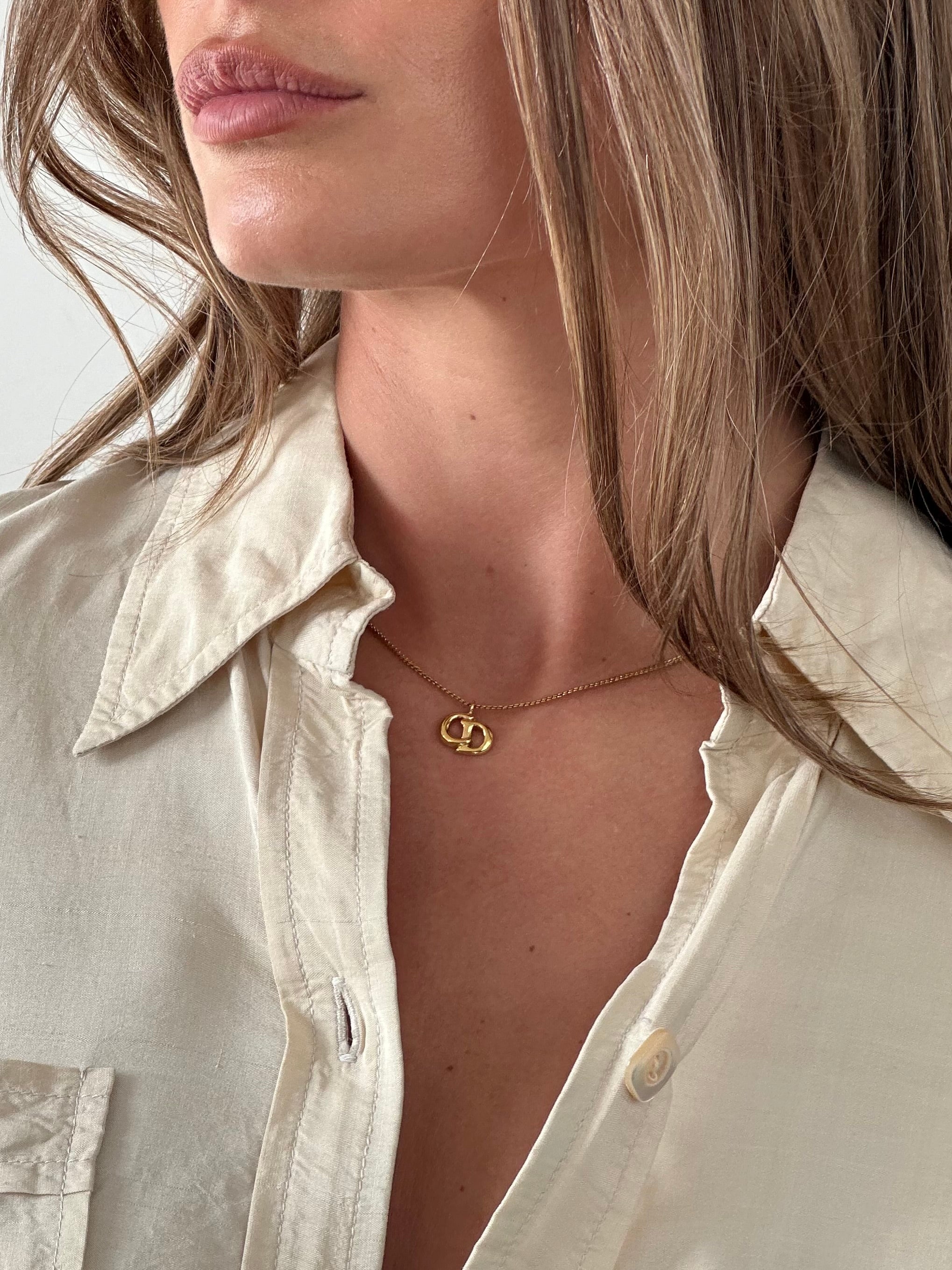 Christian Dior 16-inch gold plated logo pendant necklace with sleek, elegant design and branded charm on a delicate chain.