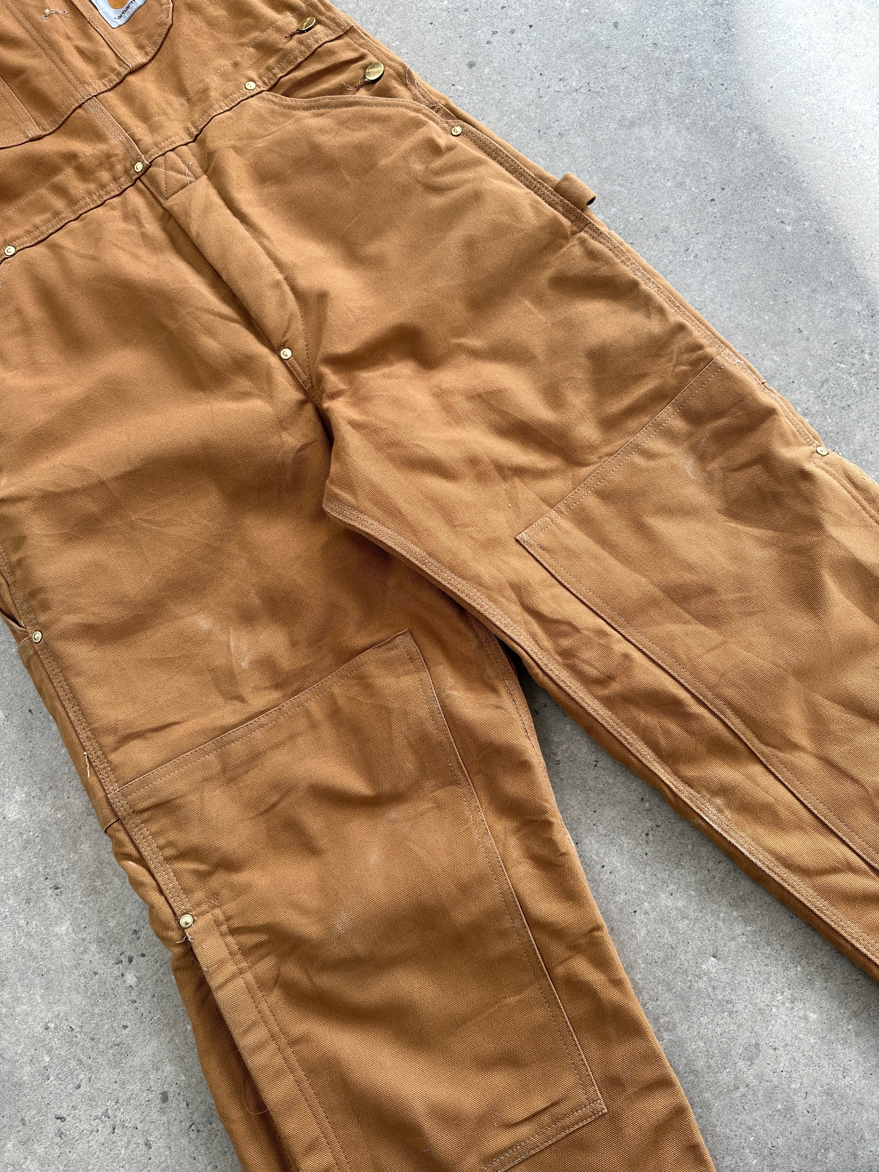 Carhartt pure cotton dungarees in size M, durable workwear with classic design and sturdy fabric, shown on a model.